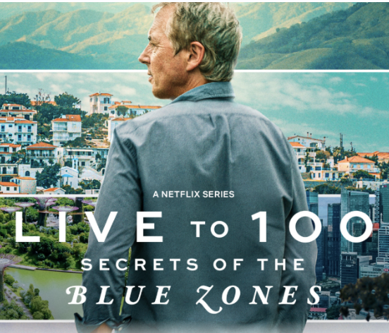 Poster for Netflix series 'Live to 100: Secrets of the Blue Zones' showing an older man with gray hair in profile, standing outdoors with a cityscape and green landscape in the background.