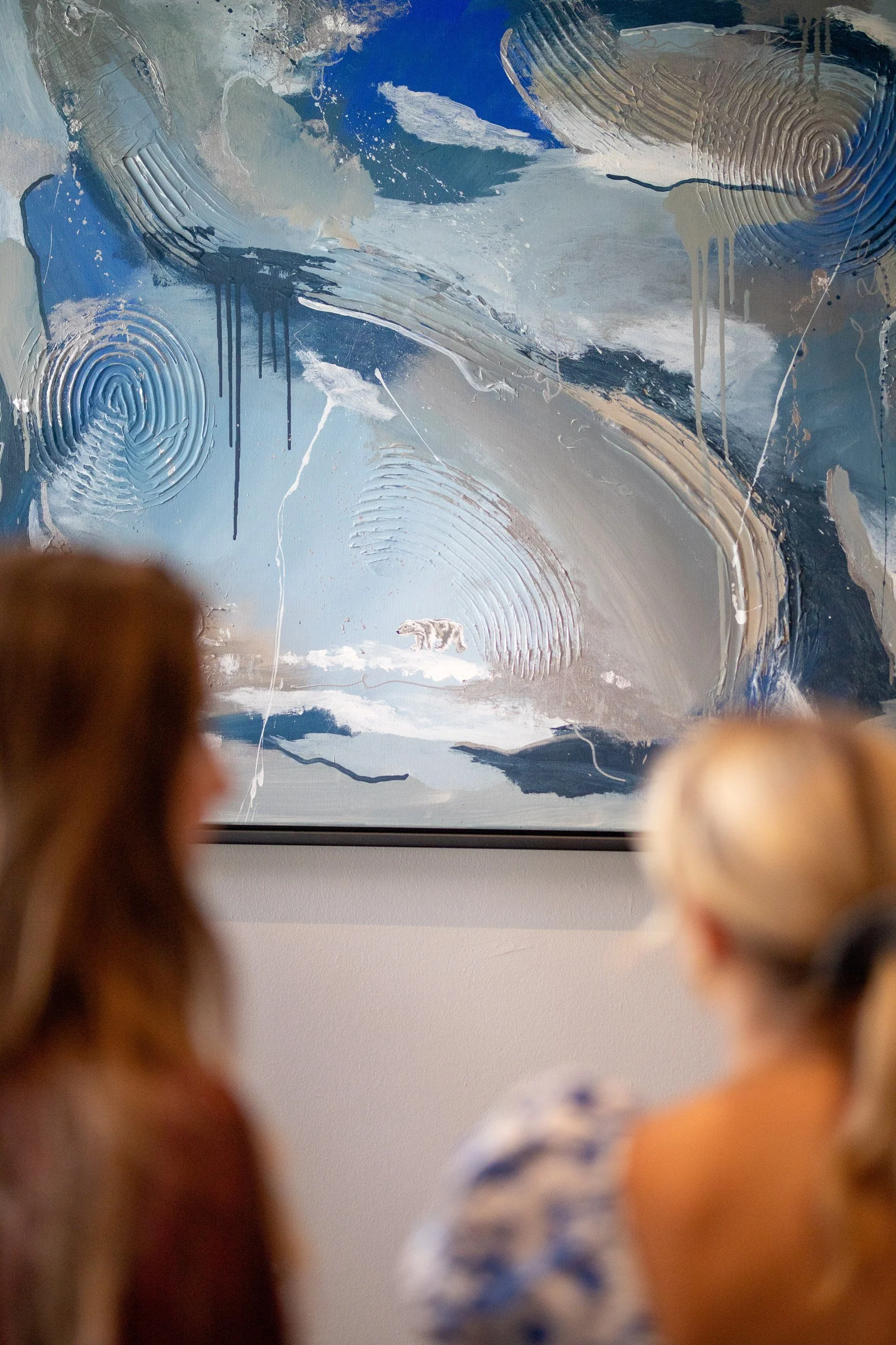 Visitors discovering the hidden polar bear in Sabrina Richter's abstract painting at a vernissage – abstrakte Kunst mit Eisbär, Kunst kaufen
