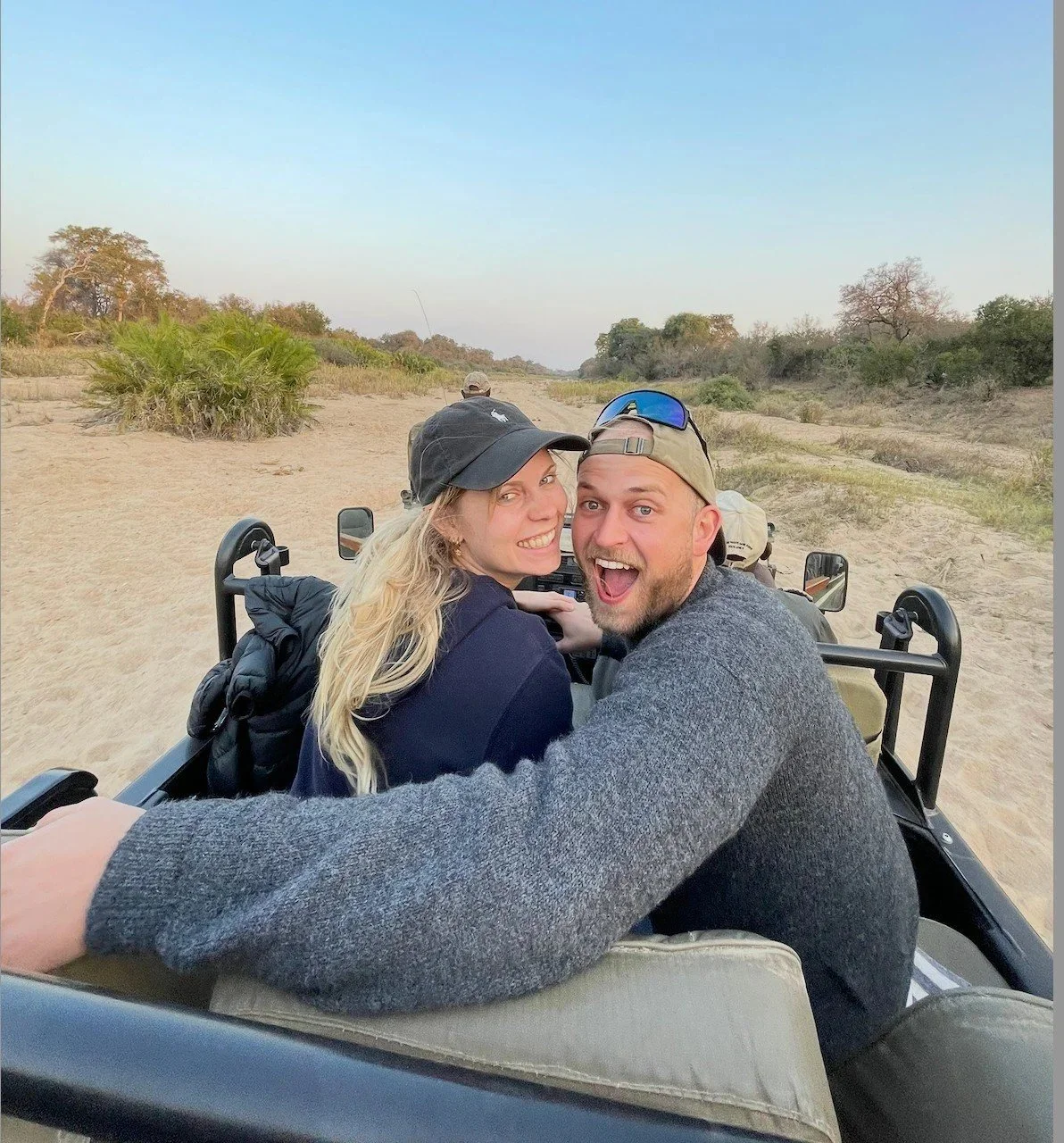 Artist Sabrina Tina Richter (Künstlerin aus Frankfurt) and Max smiling on a safari vehicle in Africa