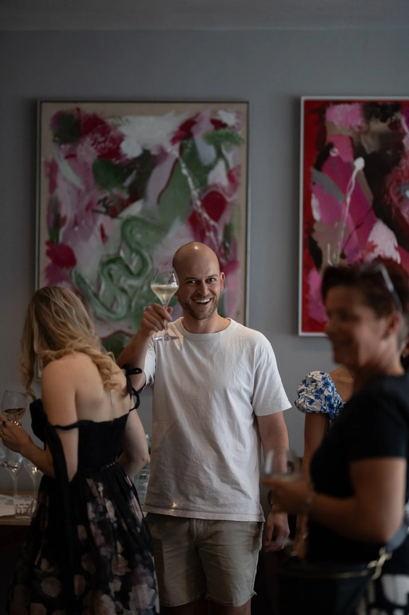 guest-raising-glass-in-front-of-abstract-paintings-vernissage-il-vino-frankfurt.jpg