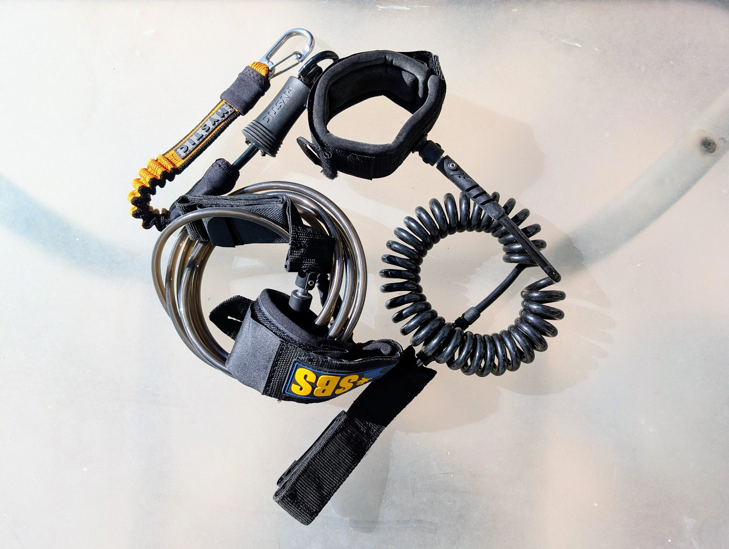 three different SUP leashes on a table