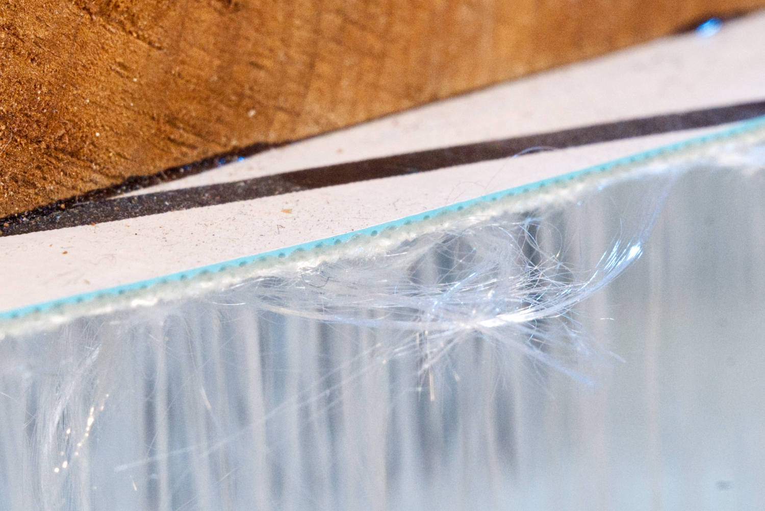 A close up picture of the cross section of the shell layer of an iSUP showing the PVC layer and underlying fabric layer.