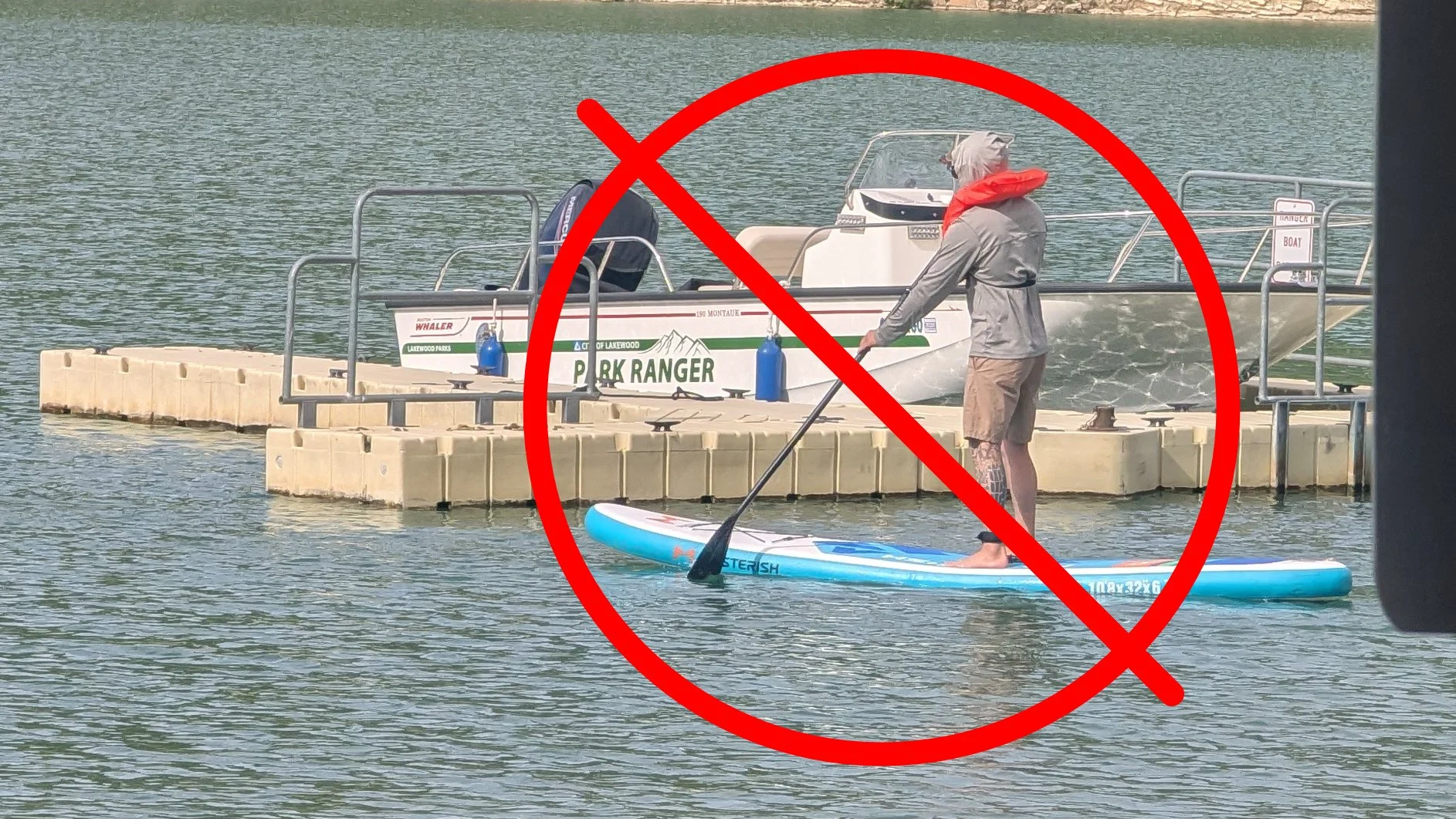 a beginner SUP paddler holding their paddle incorrectly with a red circle and line graphic overlay crossing it out.