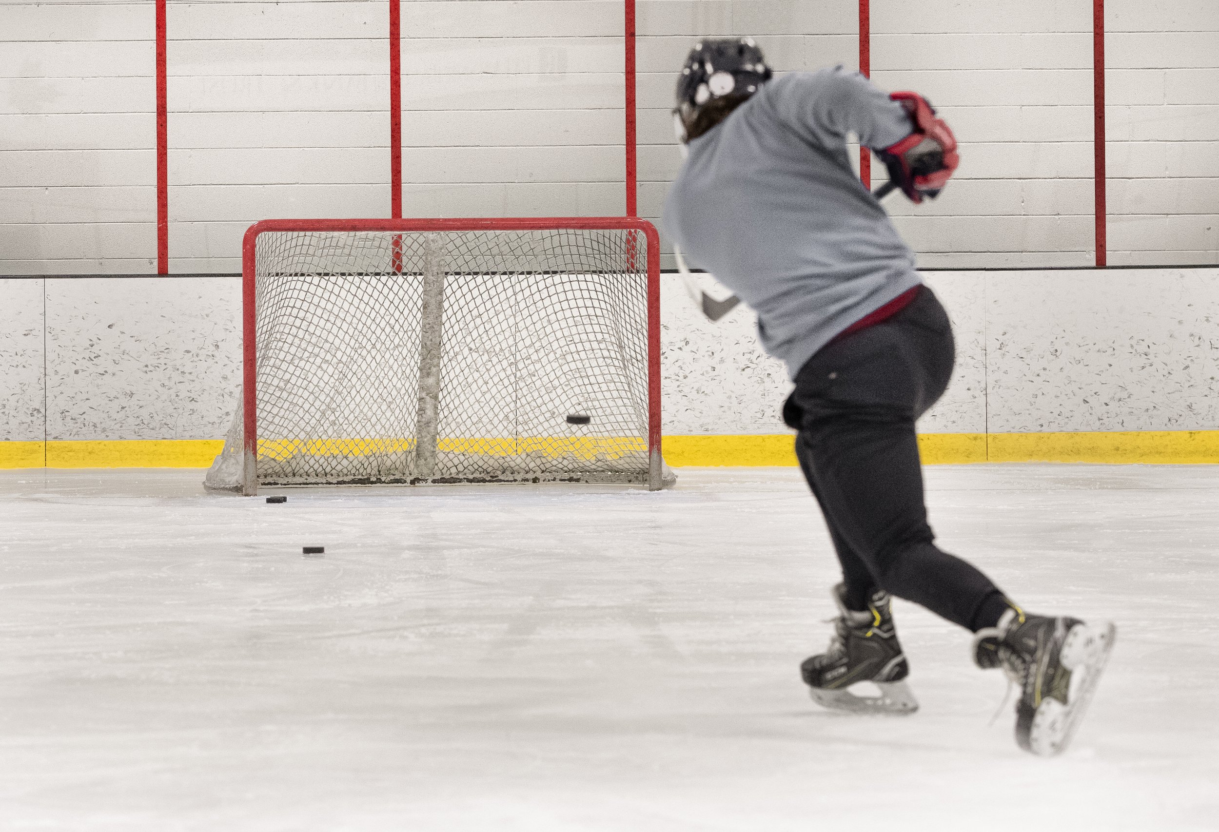 Young ice hockey player skating on the ice rink.