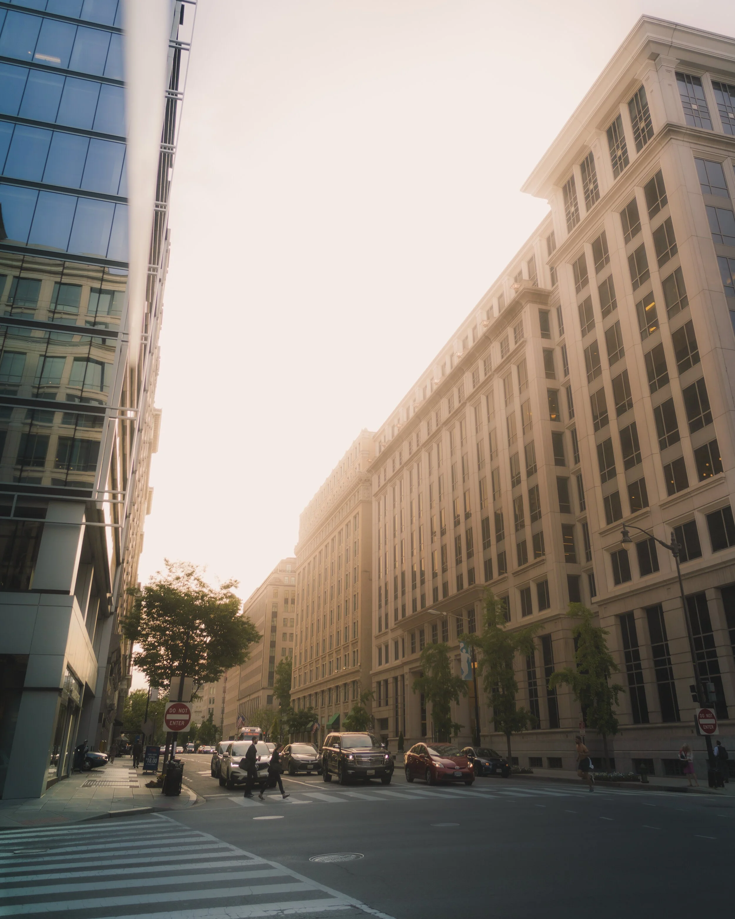 City street with tall buildings, traffic, and pedestrians
