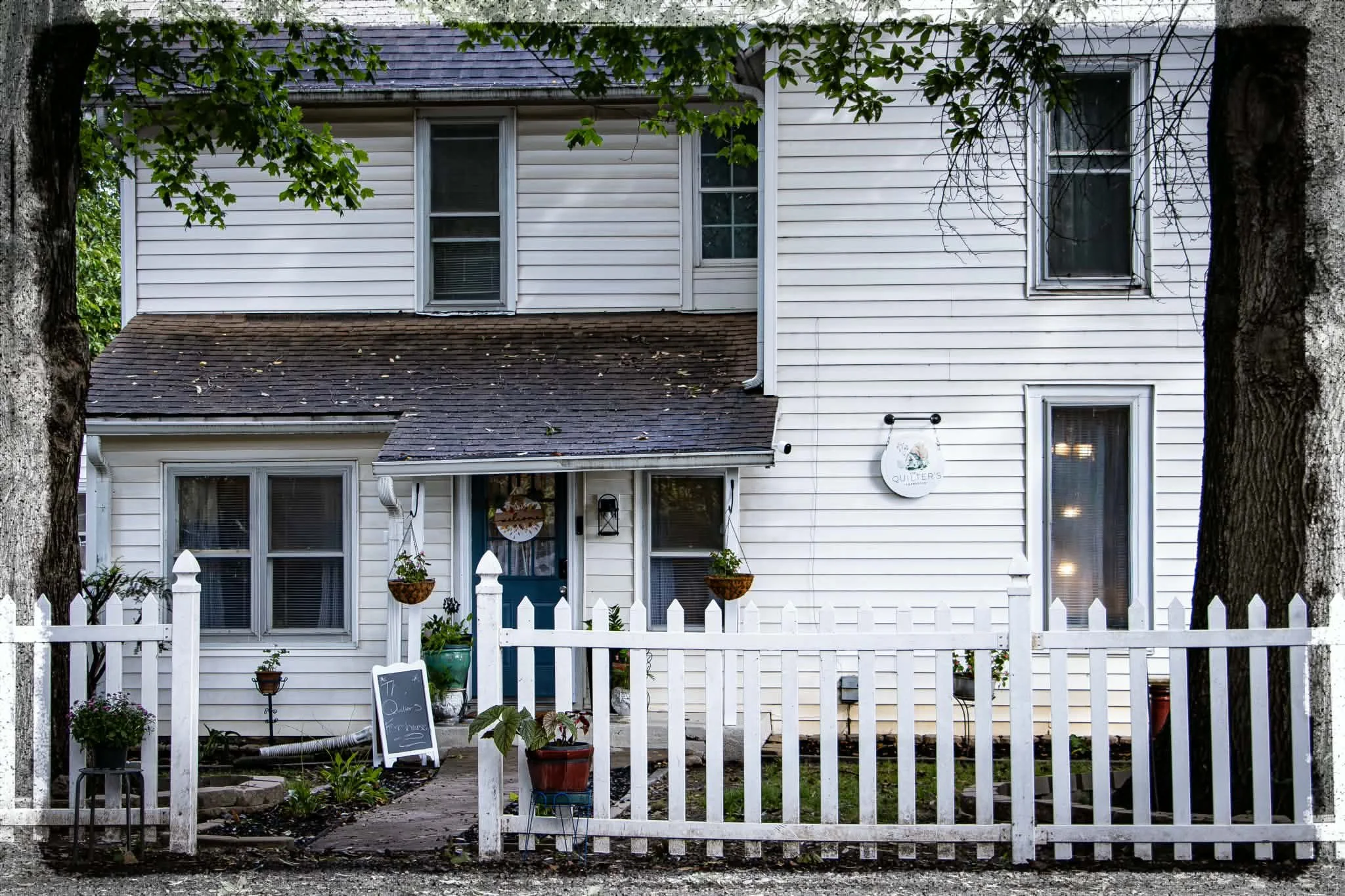 The Quilter’s Farmhouse Exterior House with Fence for quilting and sewing classes located in Independence, Missouri. 