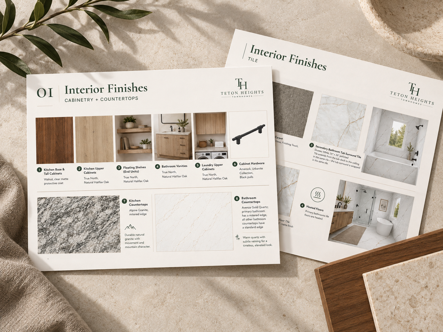 Interior design material samples and catalogs, including wood finishes, marble and tile, on a beige surface with a plant and fabric in the background.
