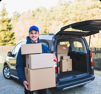 Delivery driver carrying packages from a vehicle.