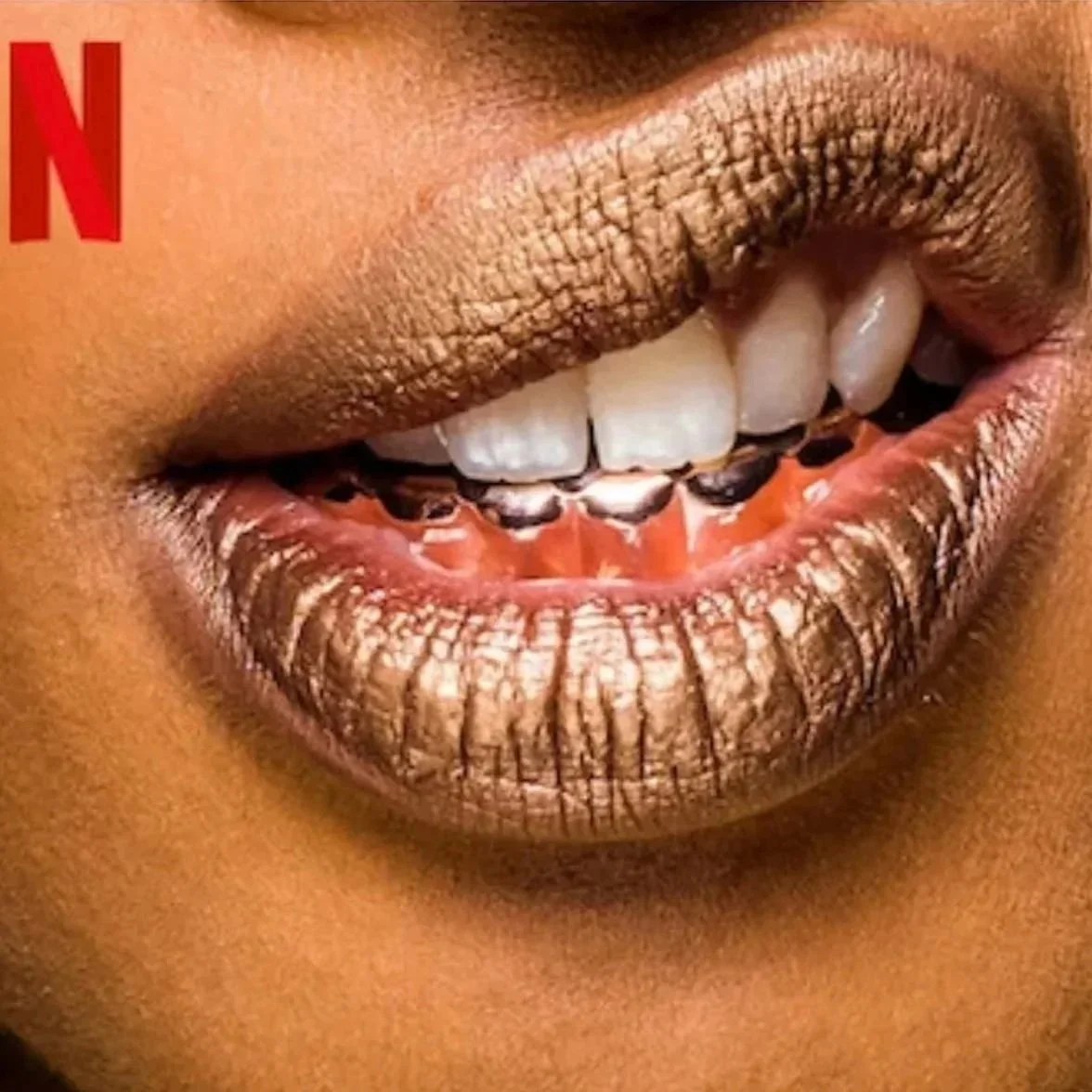 Close-up of a person smiling with colorful lipstick, showing white teeth and a hint of black teeth behind the upper teeth.