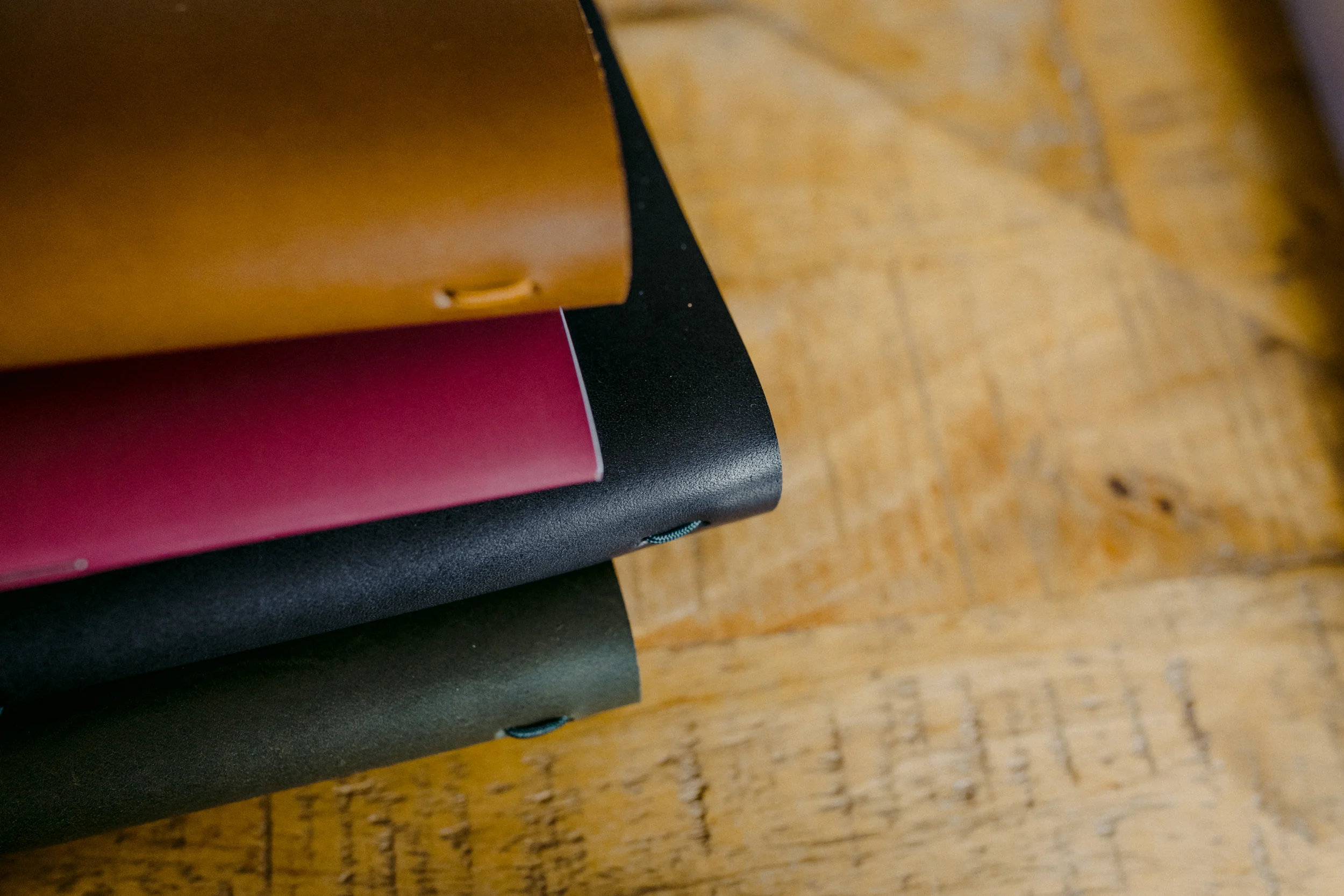 Close-up of stacked books on a wooden surface, showing the edges of the books.