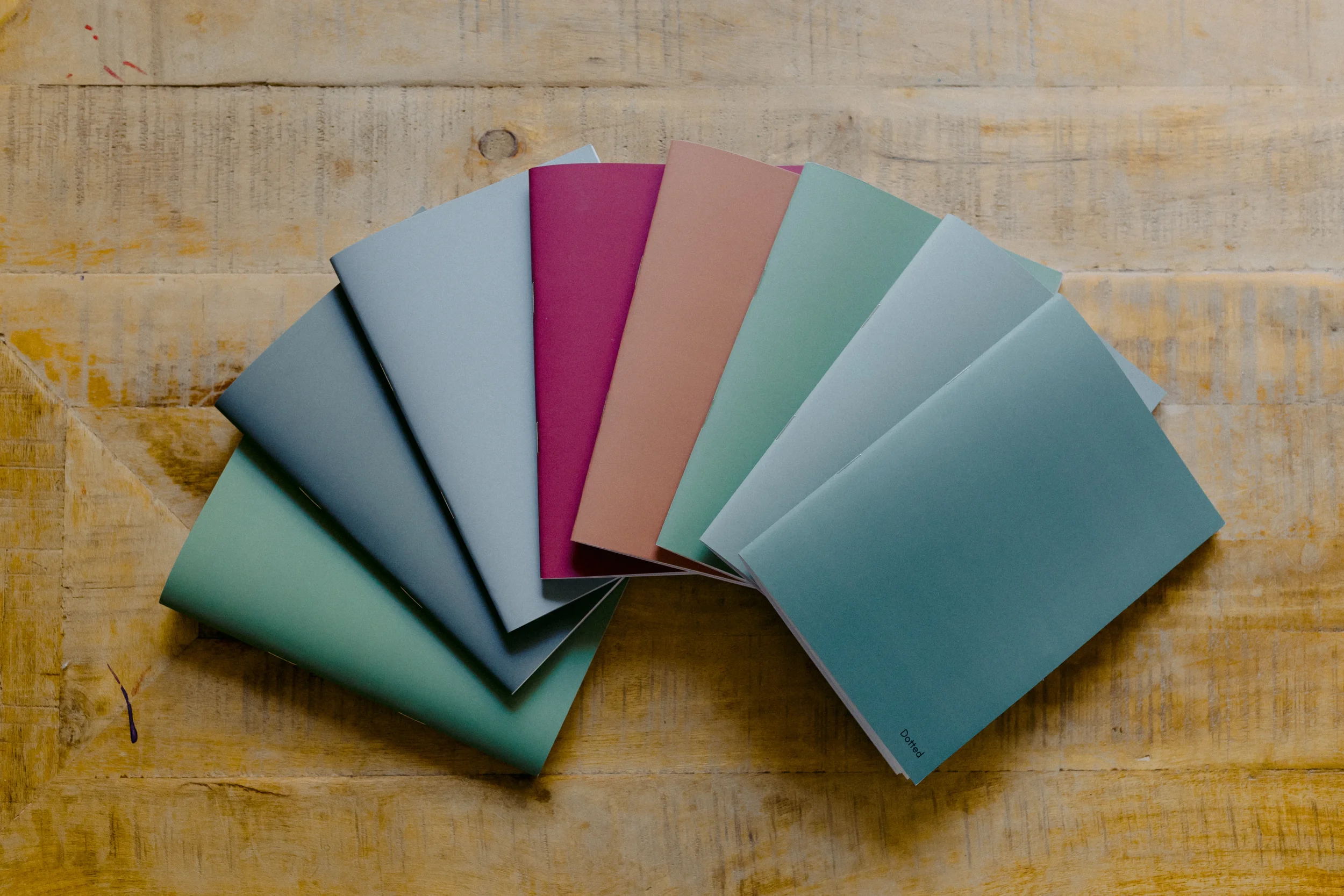 Color swatches in pastel shades arranged in a fan shape on a wooden surface.