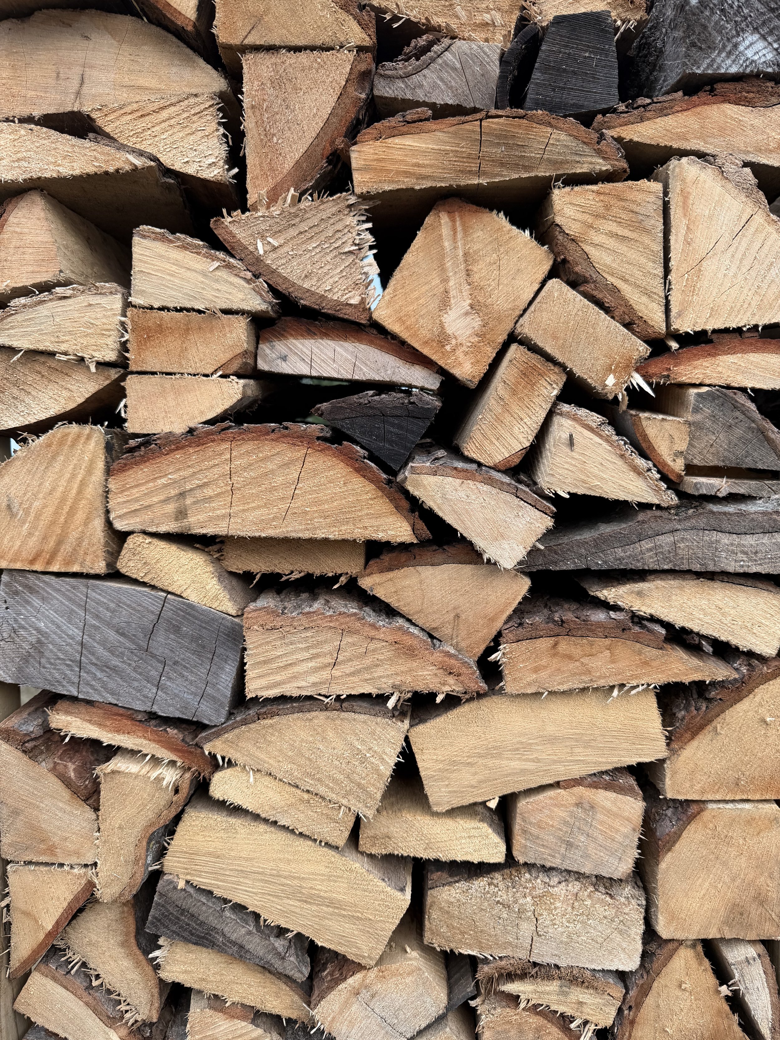 Stacked chopped firewood with visible grain and rough bark edges.