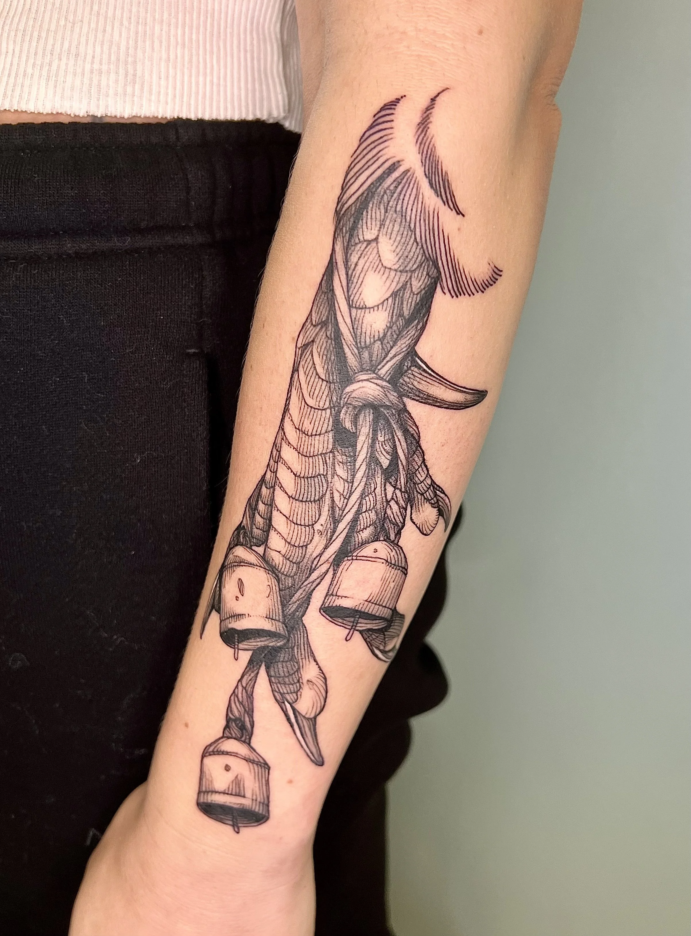 Black and gray tattoo of a crab claw on a forearm