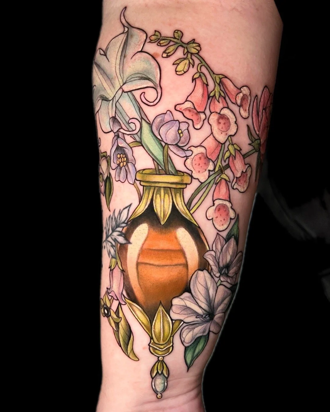 Colorful tattoo of a vintage vase with flowers on a person's arm.