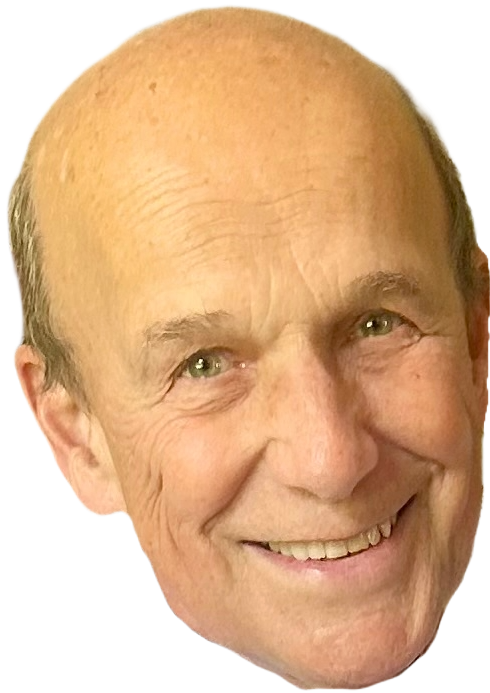 Close-up of a smiling, middle-aged man's face with light skin, bald head, and green eyes.