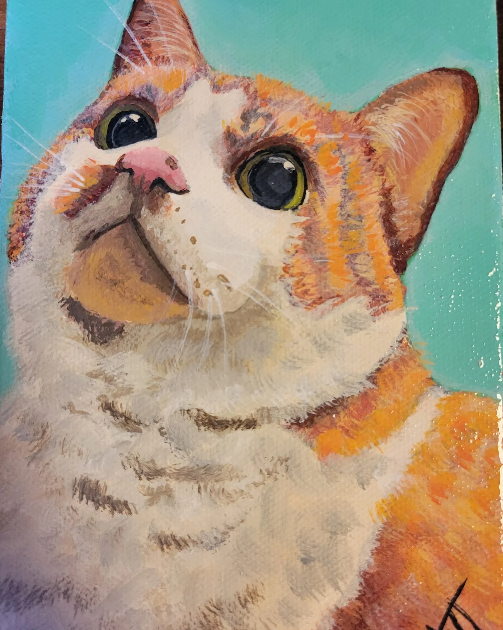Close-up of a hand-painted artwork of a kitten with large, expressive eyes, pink nose, and orange and white fur, with a background in light teal color.