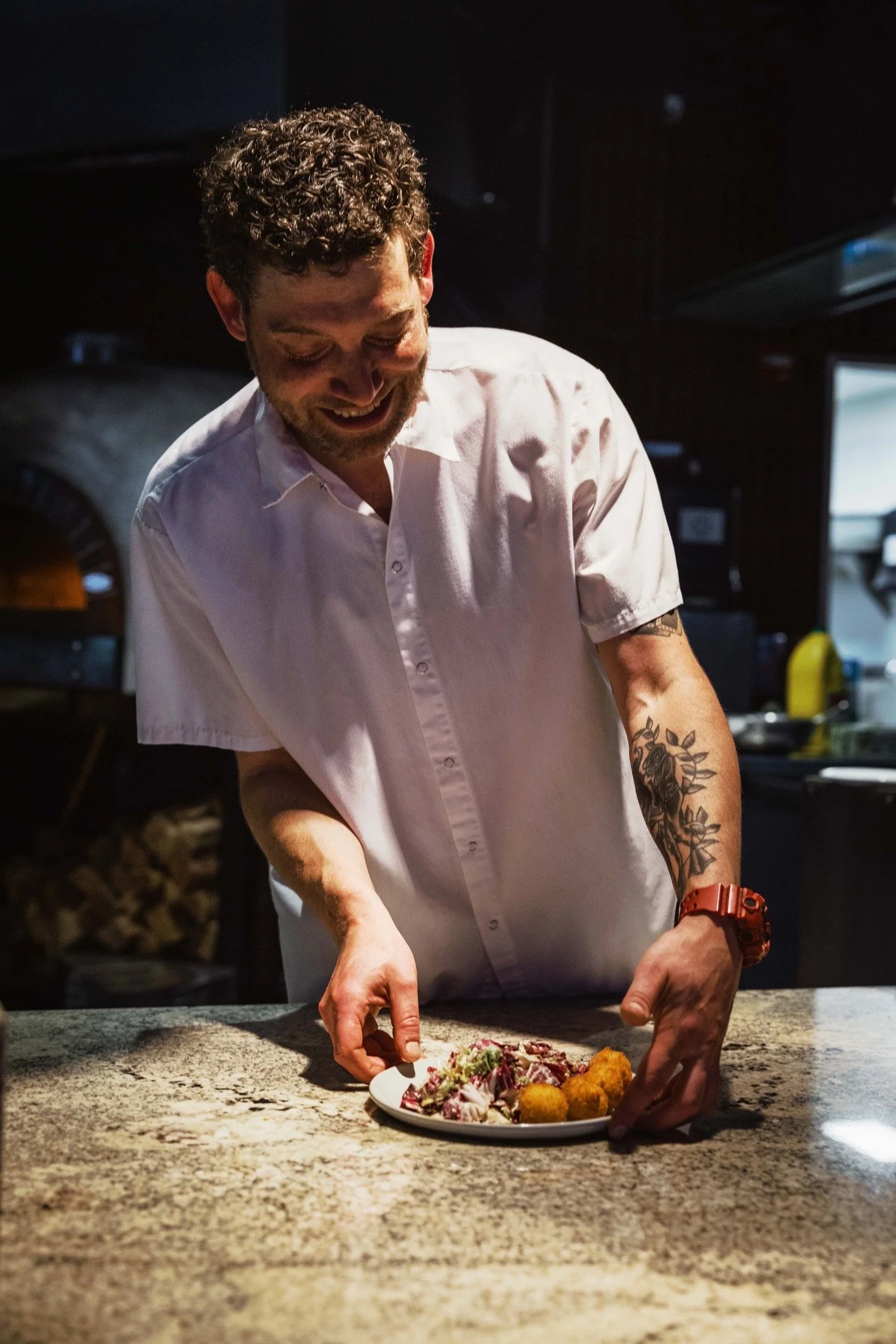 Chef David Feola plating chicory salad at Corte