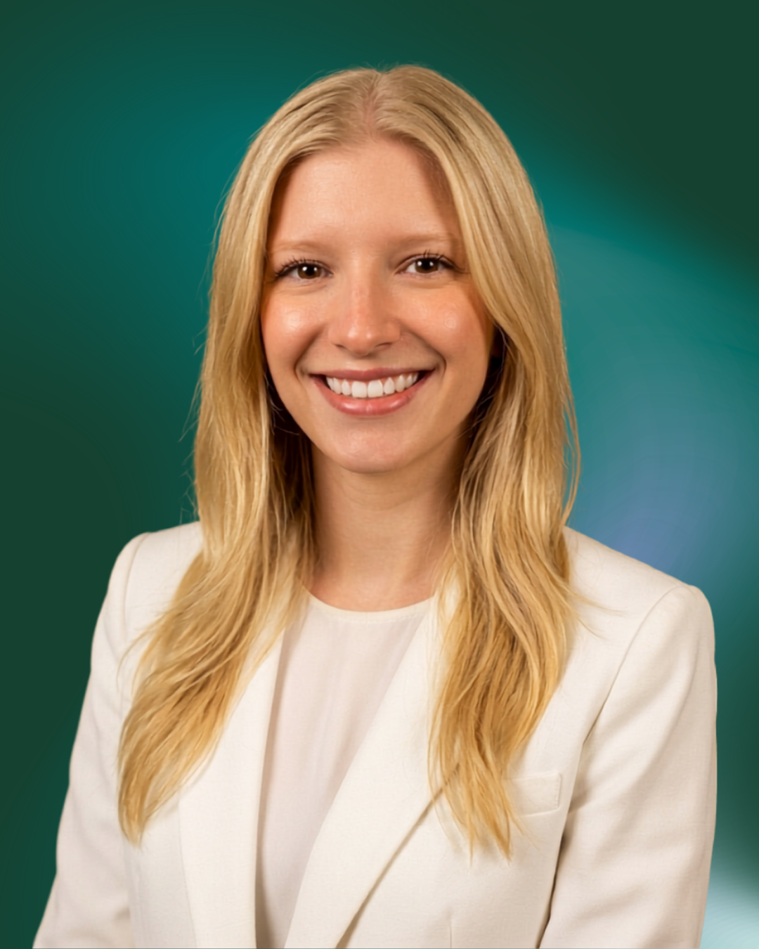 A smiling woman with long blonde hair wearing a white blazer and shirt, standing against a gradient green and blue background.