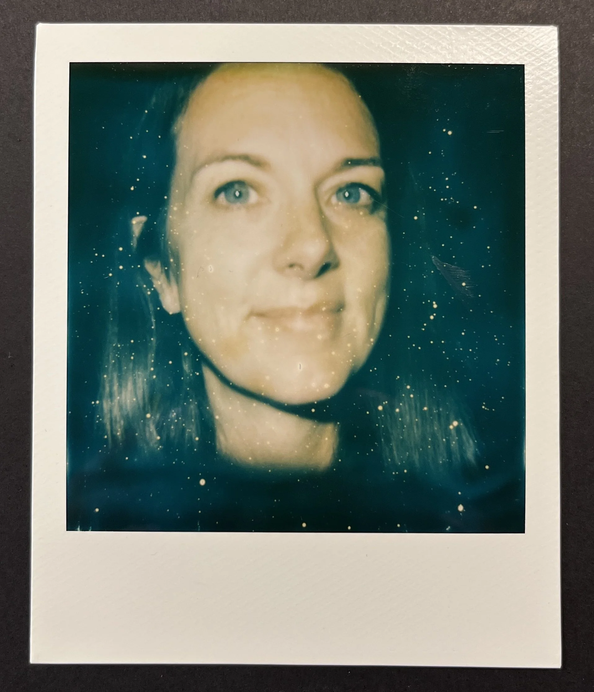 Vintage Polaroid print of a woman with blue eyes and dark hair