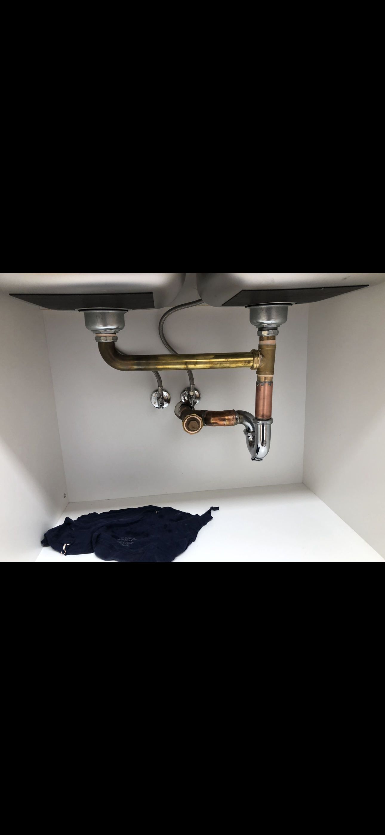Plumbing drain under a kitchen sink.