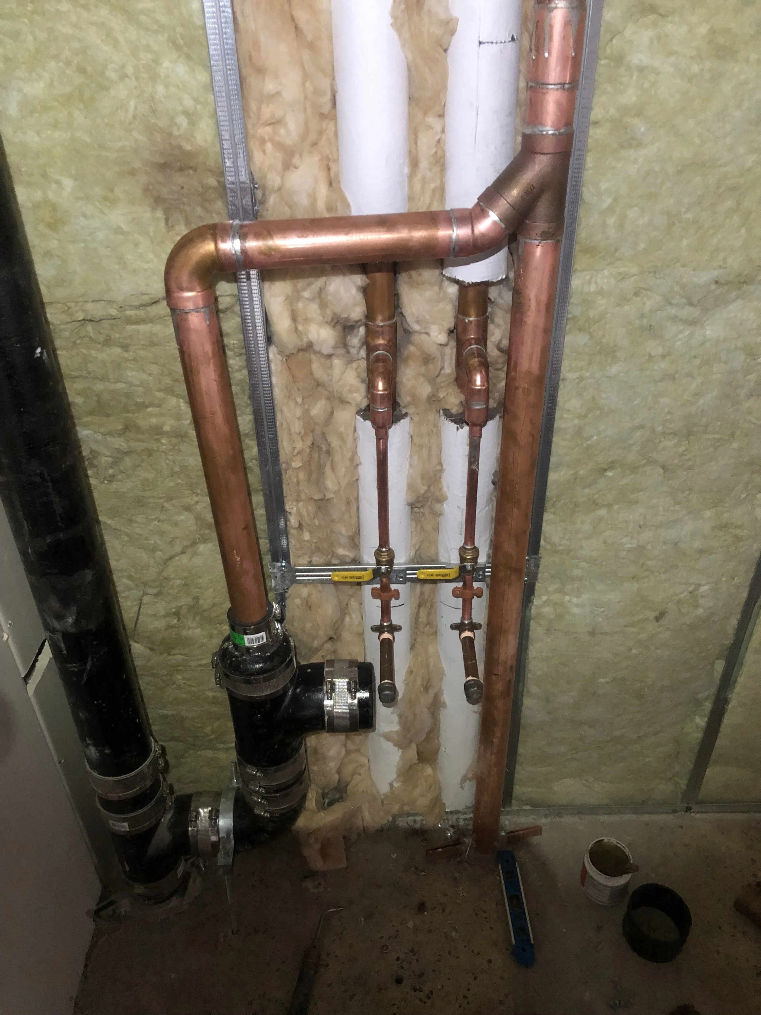 Copper Waterlines, Cast Iron, and metal framing on a partially finished wall.