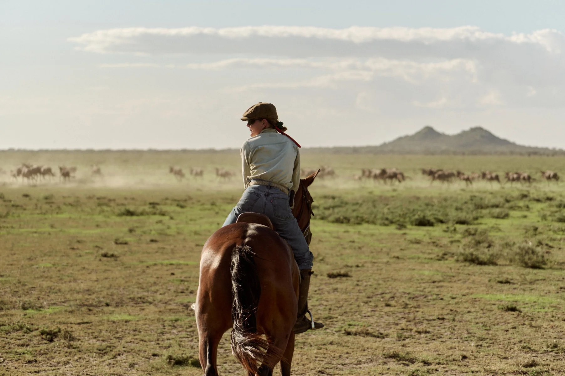 Rider on horseback looking out over the Serengeti plains