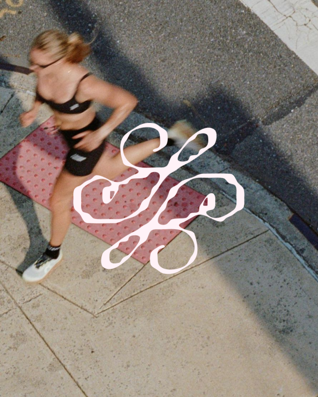 A woman jogging on a sidewalk at night, wearing black athletic wear and white sneakers with black socks, with a pink textured mat beneath her.
