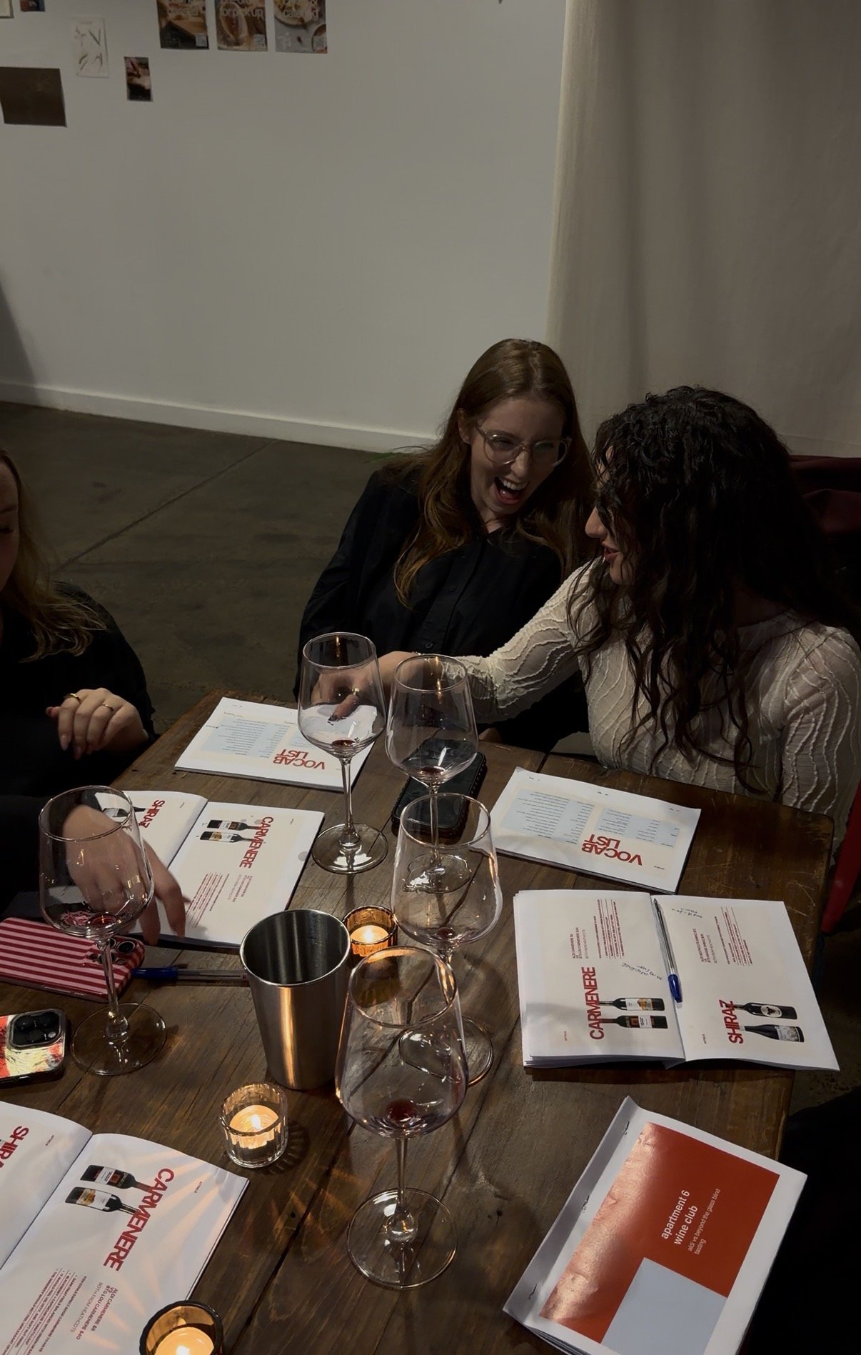 People sitting around a table with wine glasses and menus, celebrating or enjoying a meal at a restaurant.
