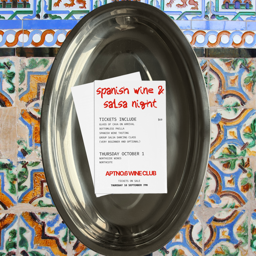 A flyer for a Spanish wine and salsa night event placed inside a shiny metal tray on a colorful tiled surface. The flyer lists ticket information, event details, and features handwritten-style red text at the top.