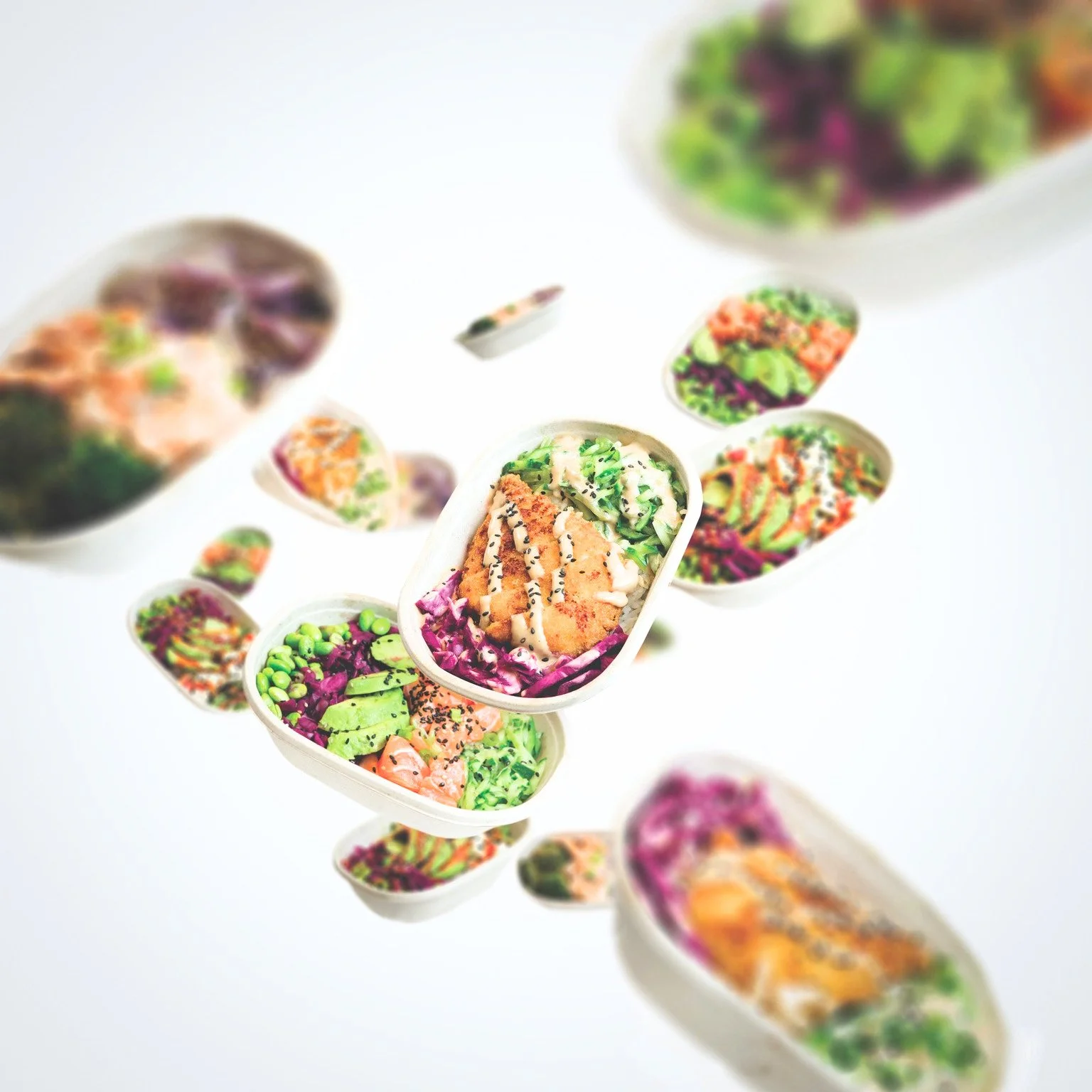 Colorful bowls of salad with various greens, vegetables, and toppings, floating above a white background.