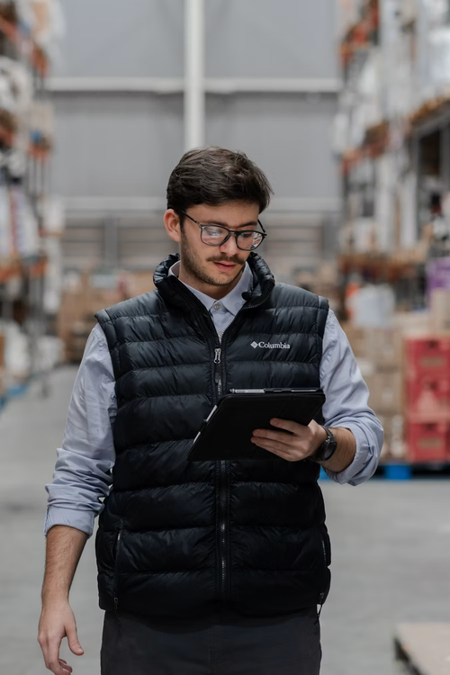 Operations lead reviewing activity on a tablet inside a distribution facility