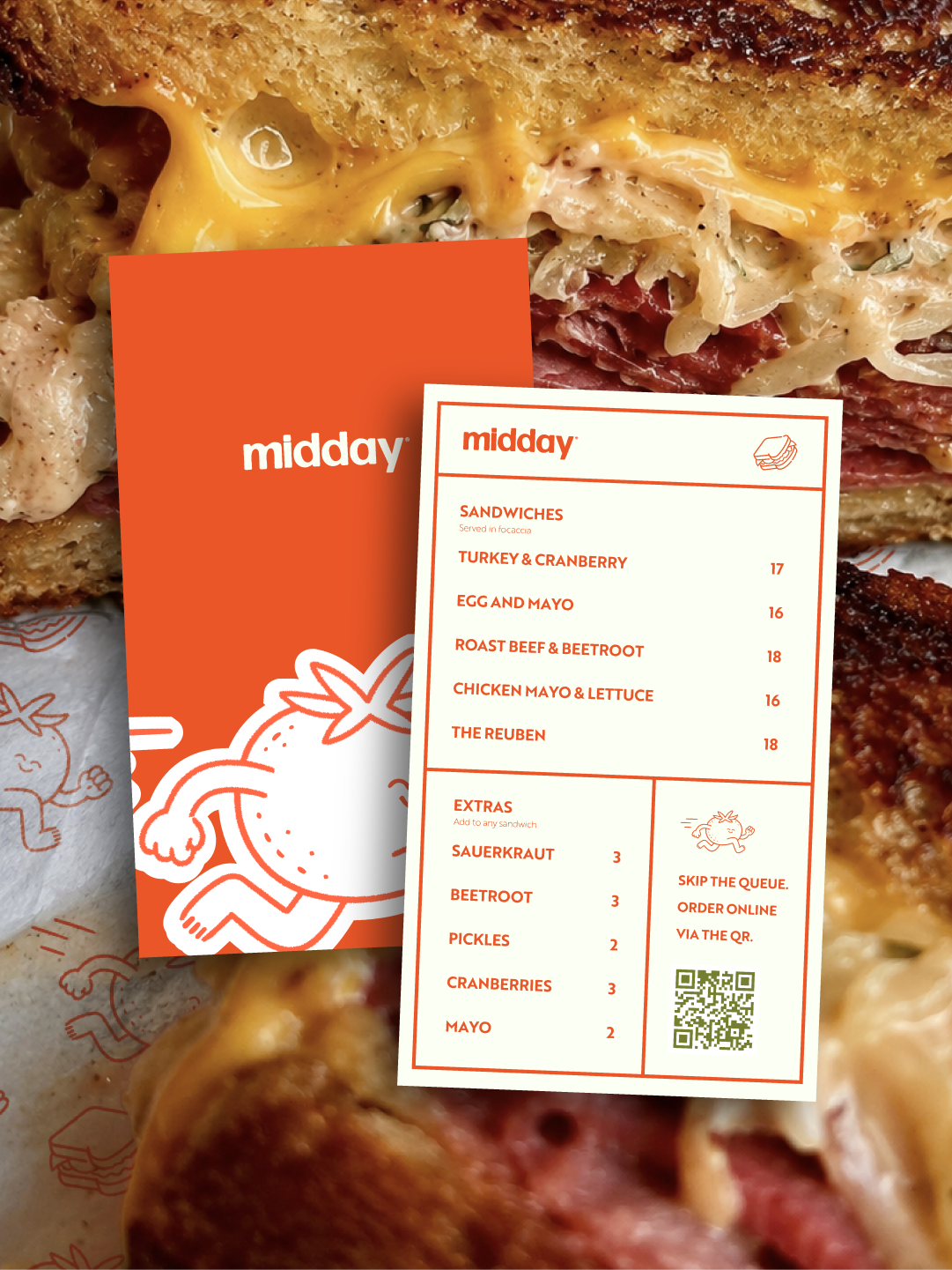 Close-up of a menu card placed on a sandwich, with visible sandwich layers including bread, turkey, cranberry, cheese, and sauce. The menu features various sandwich options and extras, with prices listed.