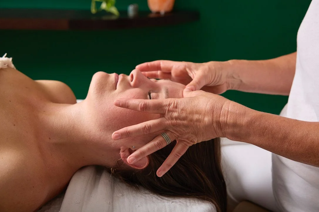 Personne recevant un massage facial dans un centre de bien-être.