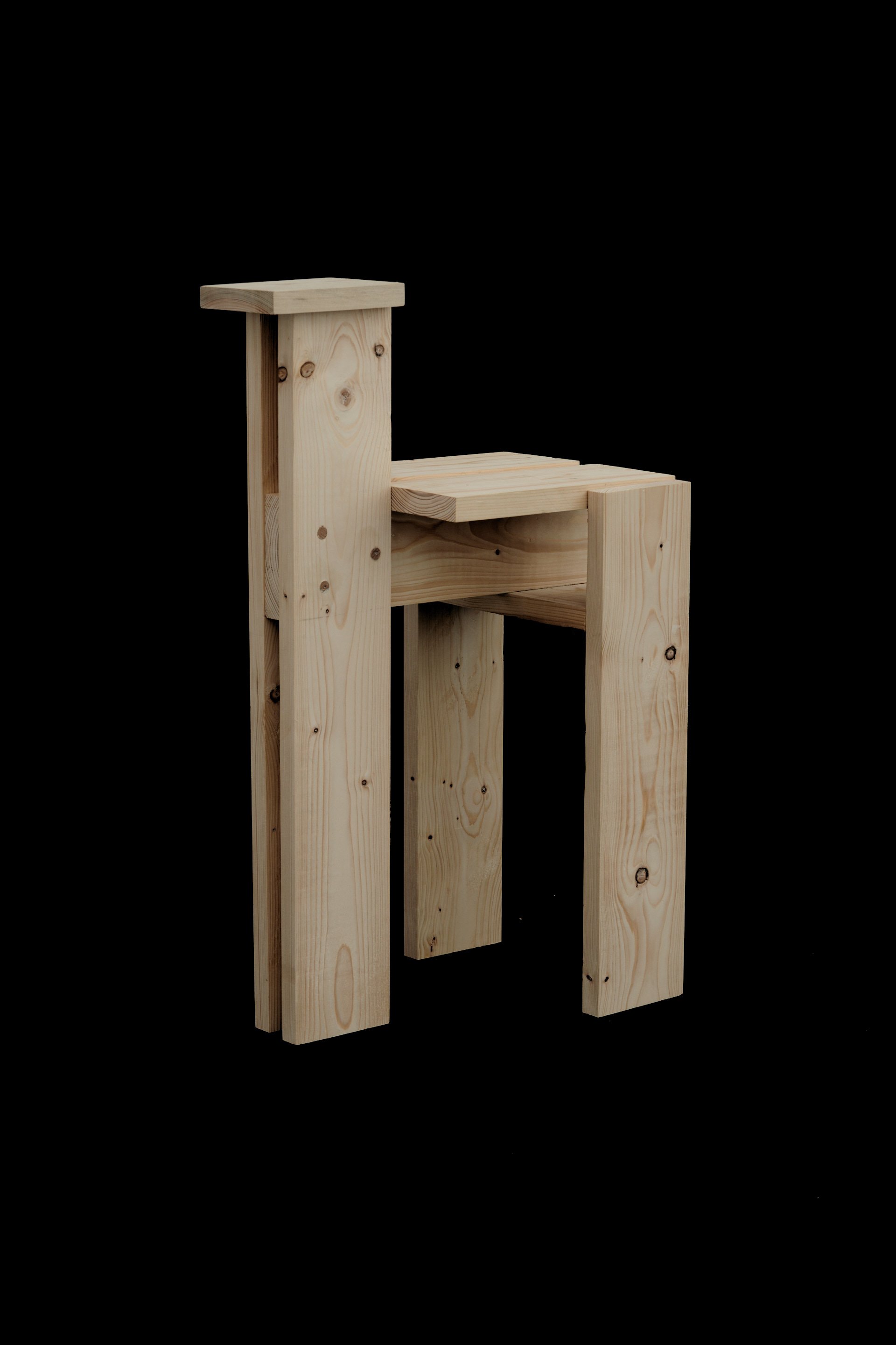 Un wooden chair made of unfinished light-colored wood with a simple design, set against a black background.
