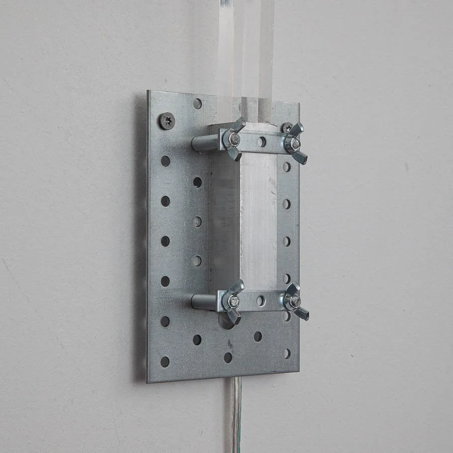Metallhalterung an einer Wand, vermutlich für eine Kabeldurchführung oder eine elektrische Komponente.