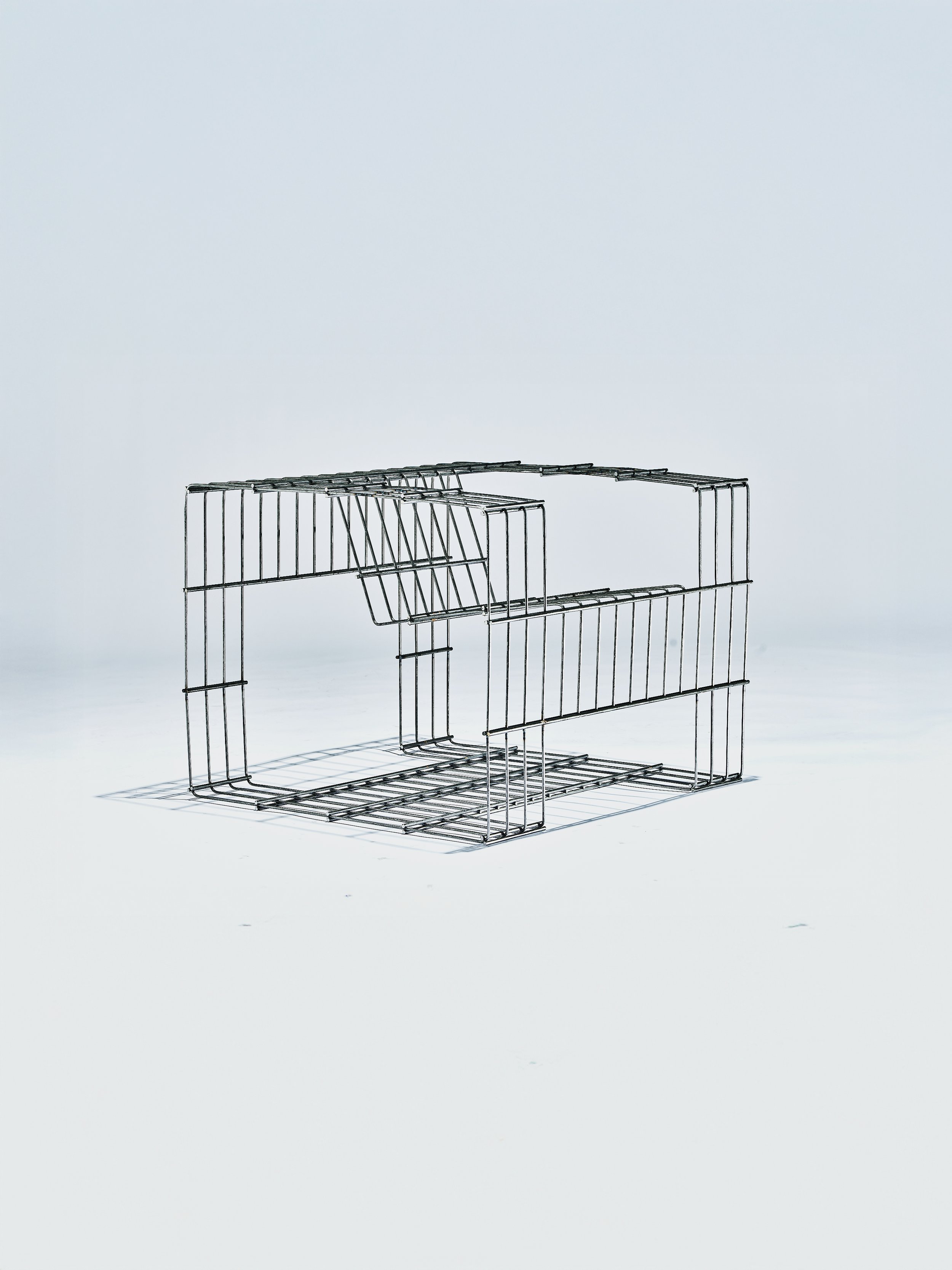 Ein faltbarer Wäschekorb aus Metall auf weißem Hintergrund.