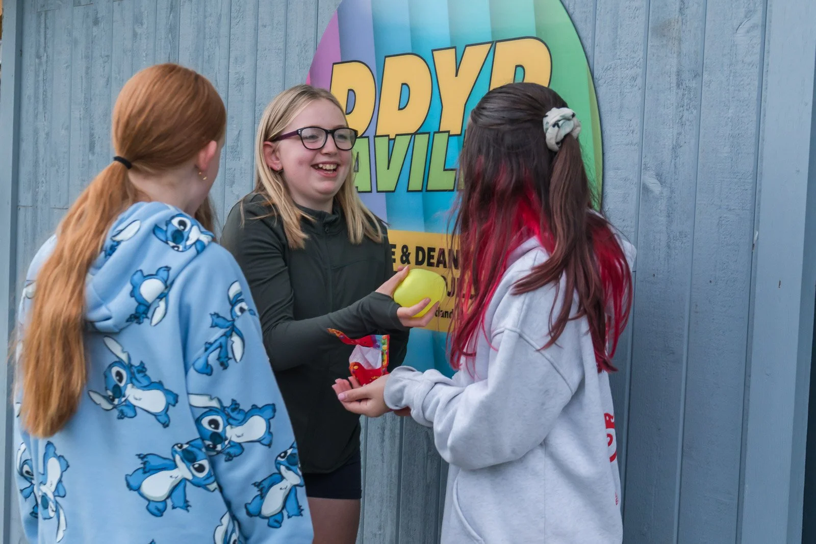 Three girls are conversing in front the DDYP pavillion in Doune.