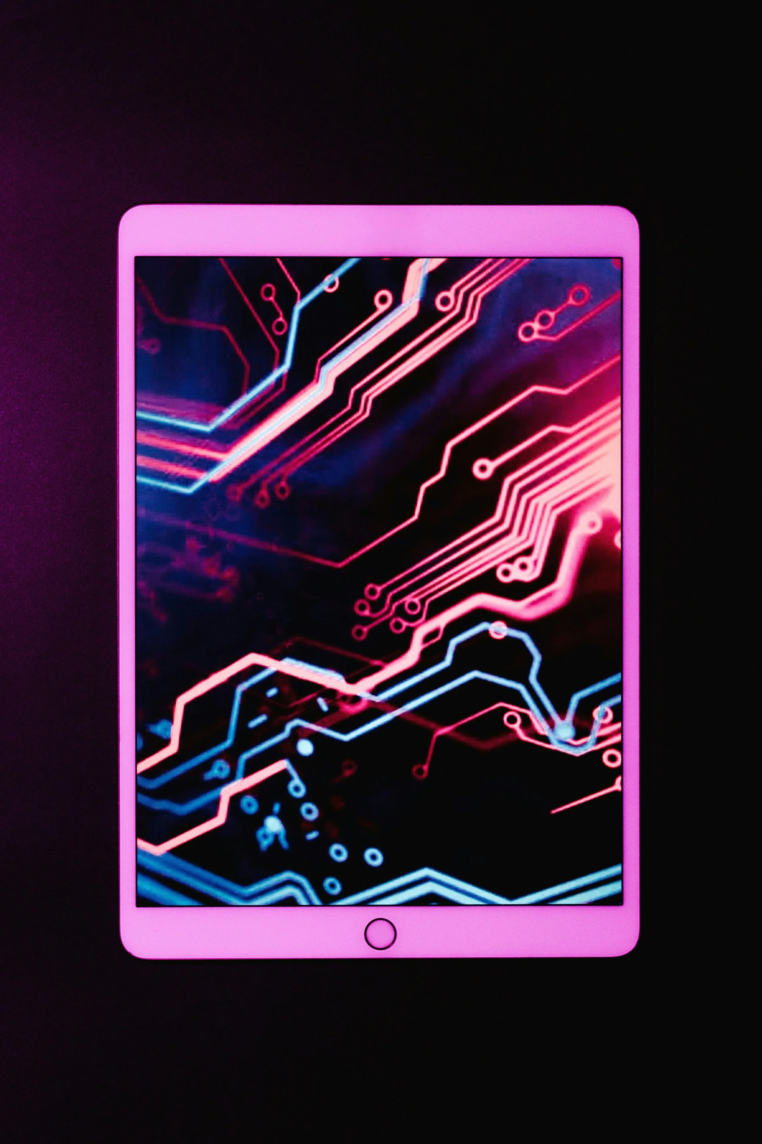 Pink smartphone displaying a colorful circuit board digital pattern on the screen, set against a black background.