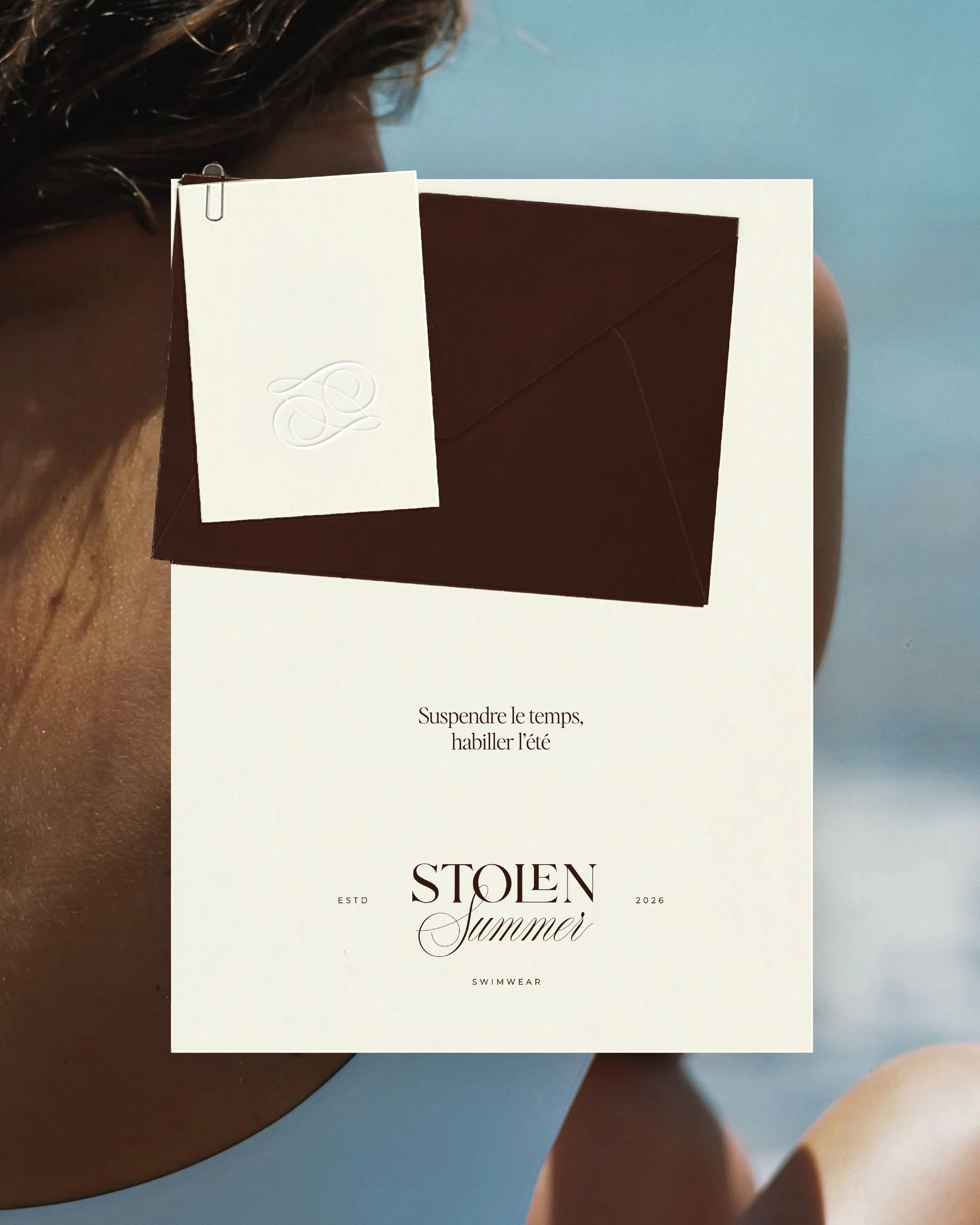 Une affiche de mode d'été mettant en avant un maillot de bain, avec le texte en français : "Suspendre le temps, habiller l'été" et le nom de la marque "Stolen Summer".