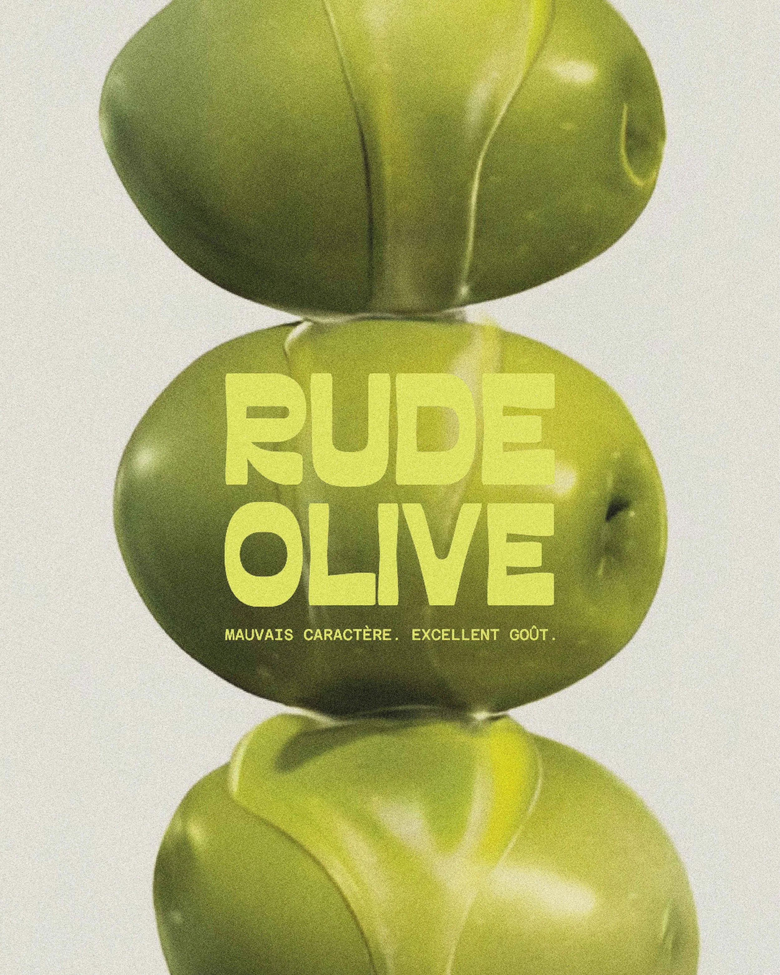 Une image de plusieurs olives vertes empilées, certaines avec du texte jaune indiquant "RUBY OLIVE" et une phrase en français en dessous.
