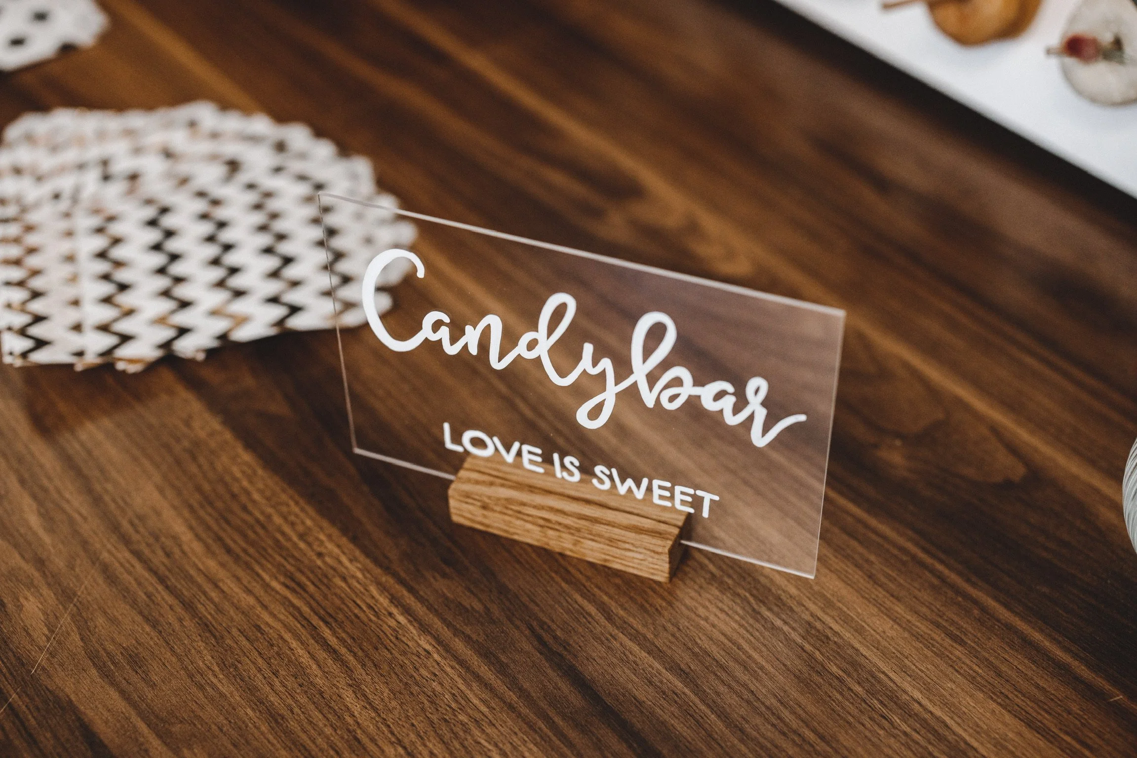 Transparentes Acrylschild mit der Aufschrift Candybar auf einem Holzständer