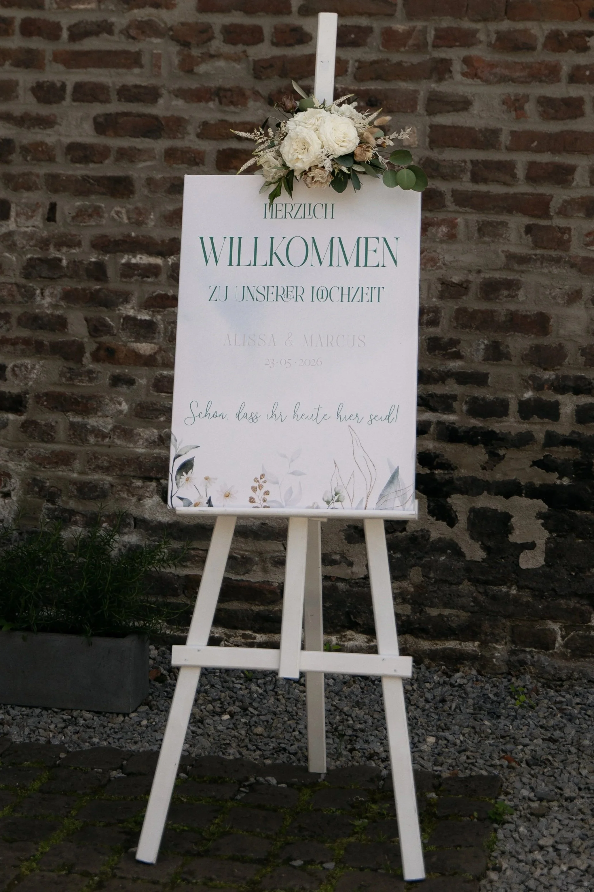 Willkommensschild zur Hochzeit auf einer Staffelei mit floraler Dekoration