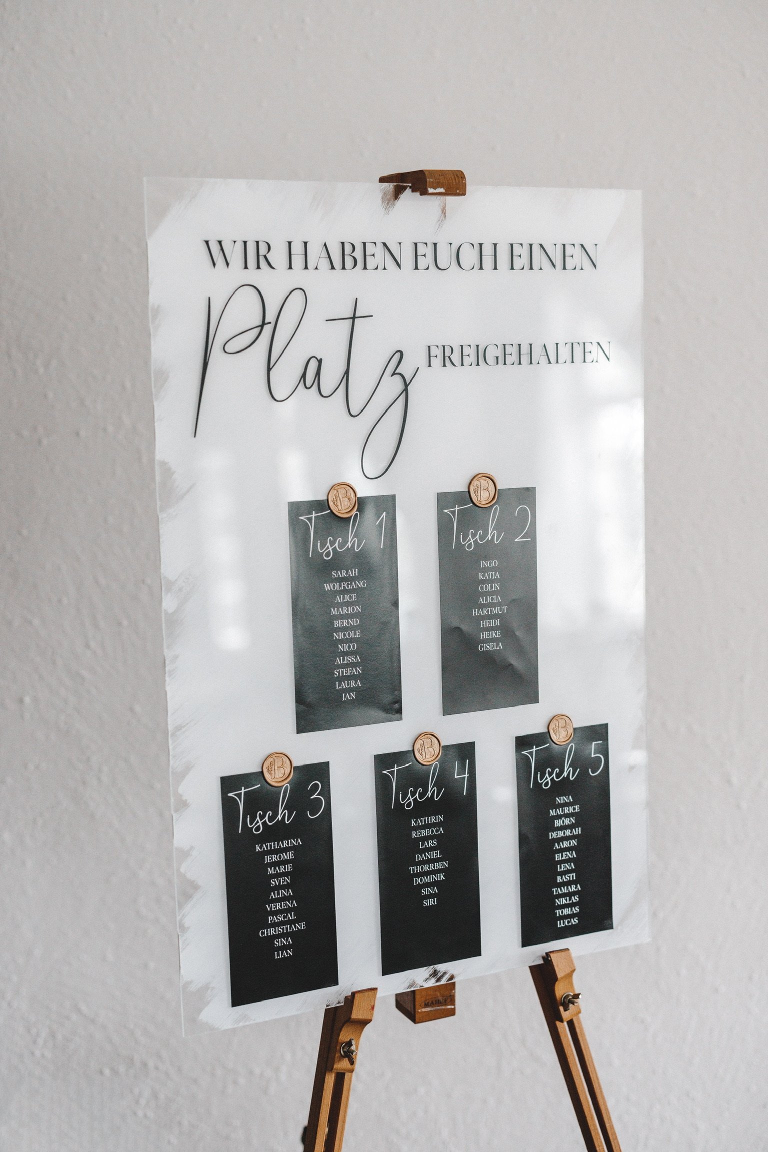 Hochzeitssitzplan auf Staffelei mit einzelnen schwarzen Namenskarten