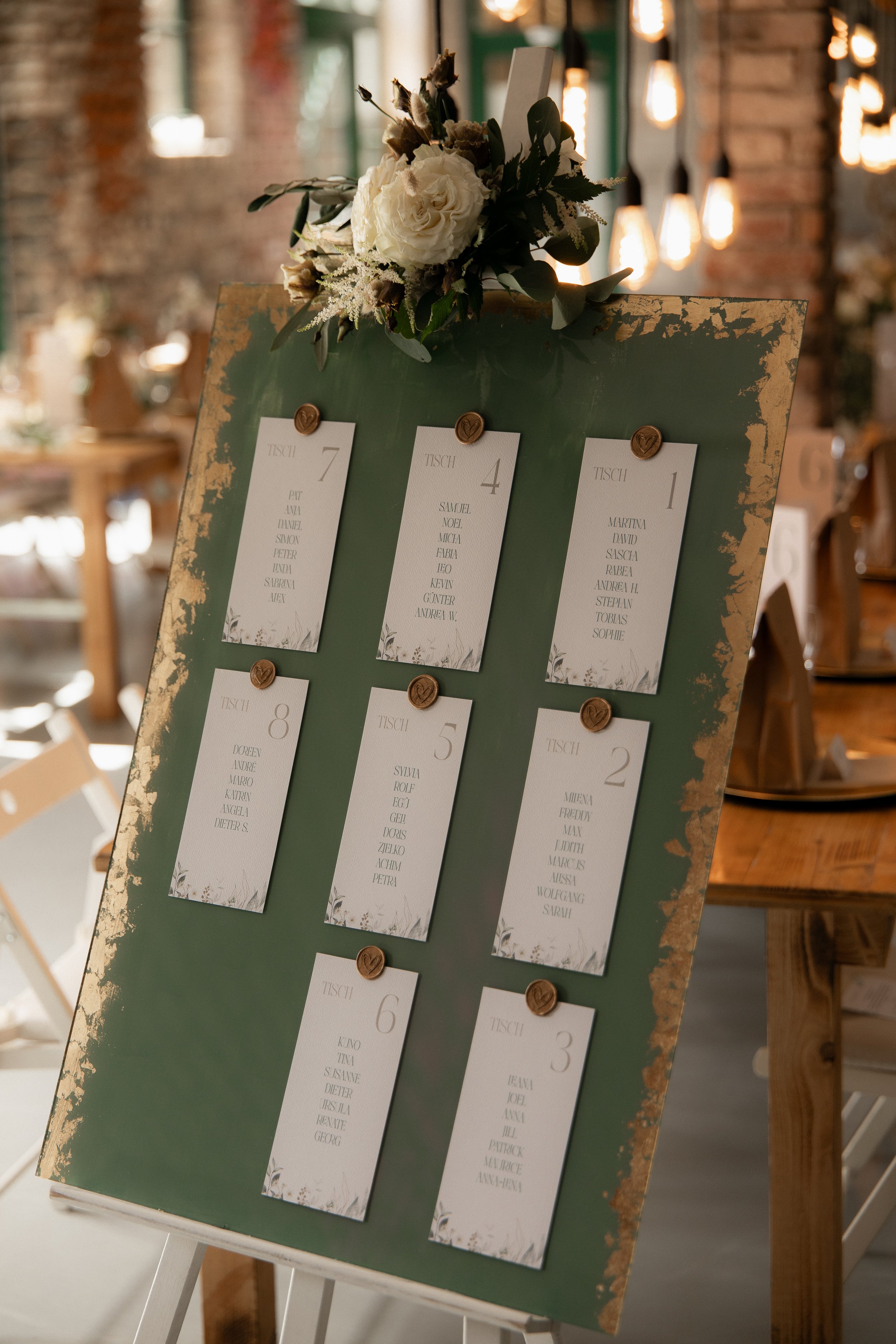 Grüner Hochzeitssitzplan mit goldveredelten Details und einzelnen Namenskarten