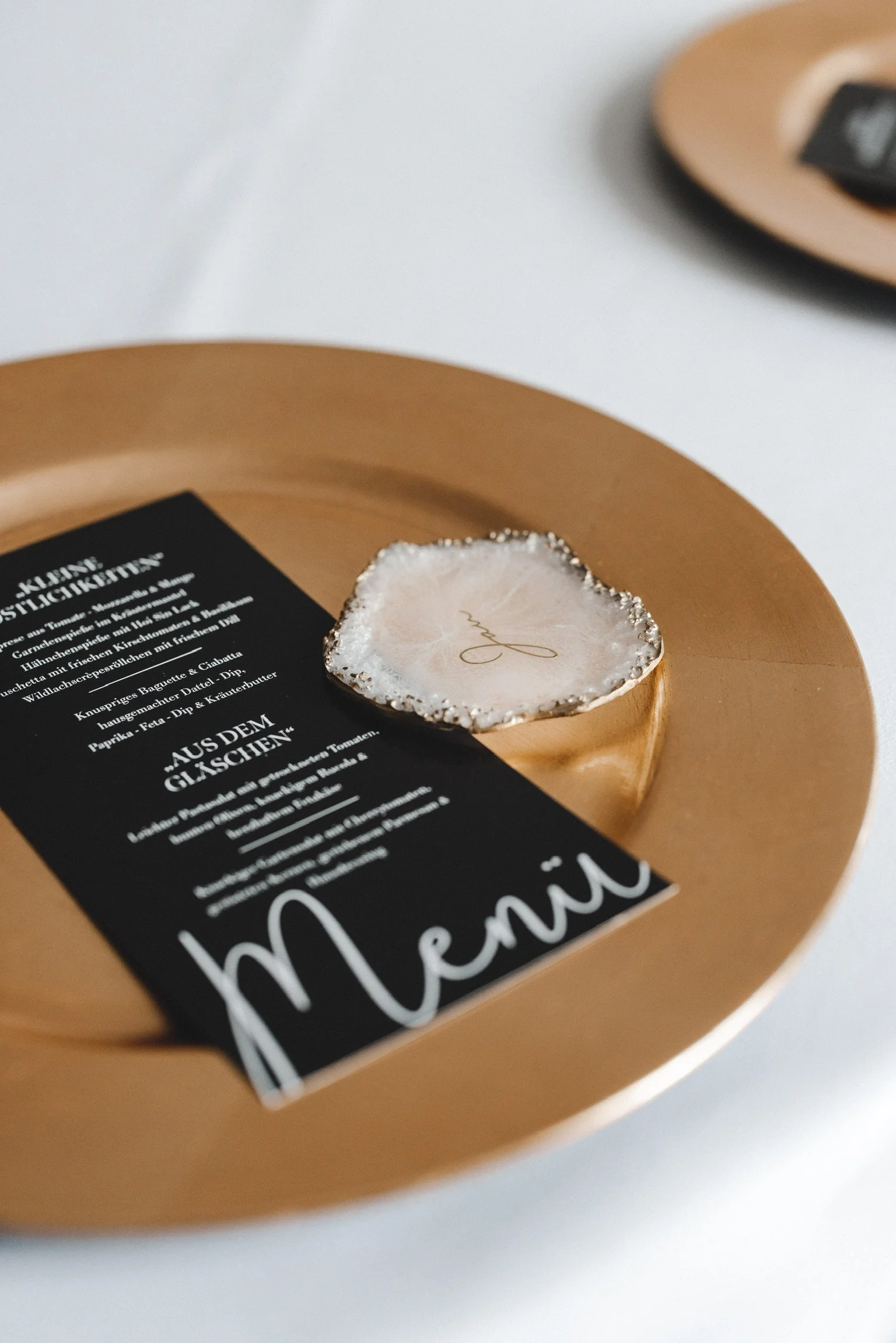 Schwarze Menükarte mit weißer Schrift auf einem gedeckten Hochzeitstisch