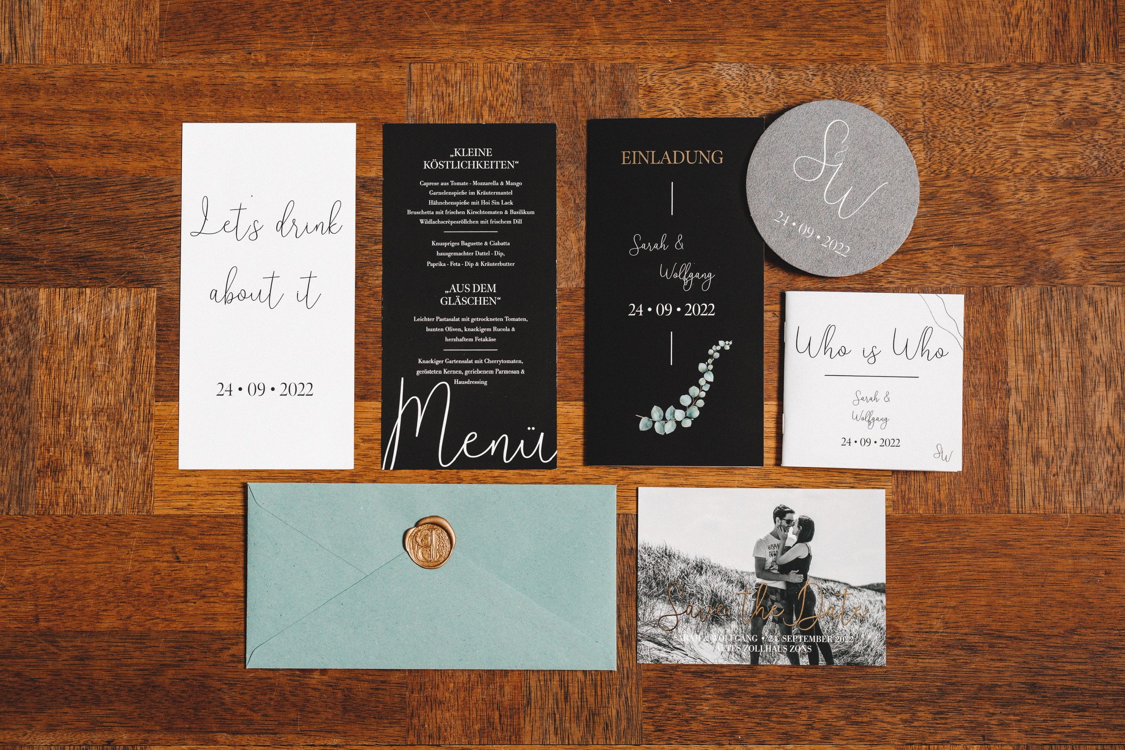 Hochzeitspapeterie mit Menükarte, Einladung, Umschlag und kleinen Details auf einem Holztisch