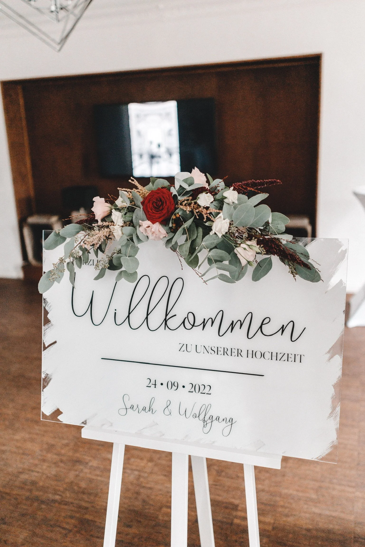 Handgefertigtes Willkommensschild zur Hochzeit mit floraler Dekoration