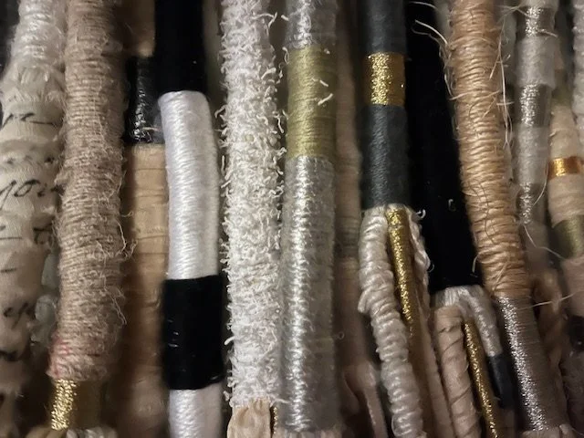Close-up of assorted spools of embroidery or sewing thread in various colors and textures.