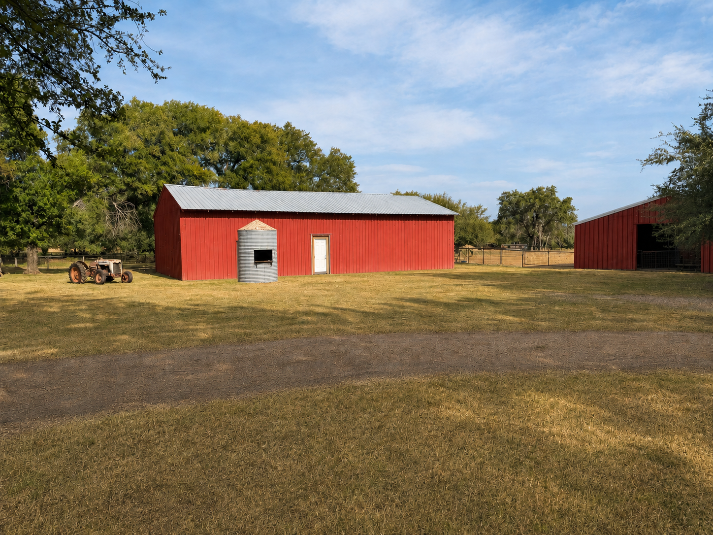 A rural farm scene with two red wooden barns, a metal grain silo, a tractor, and trees in the background under a partly cloudy sky.