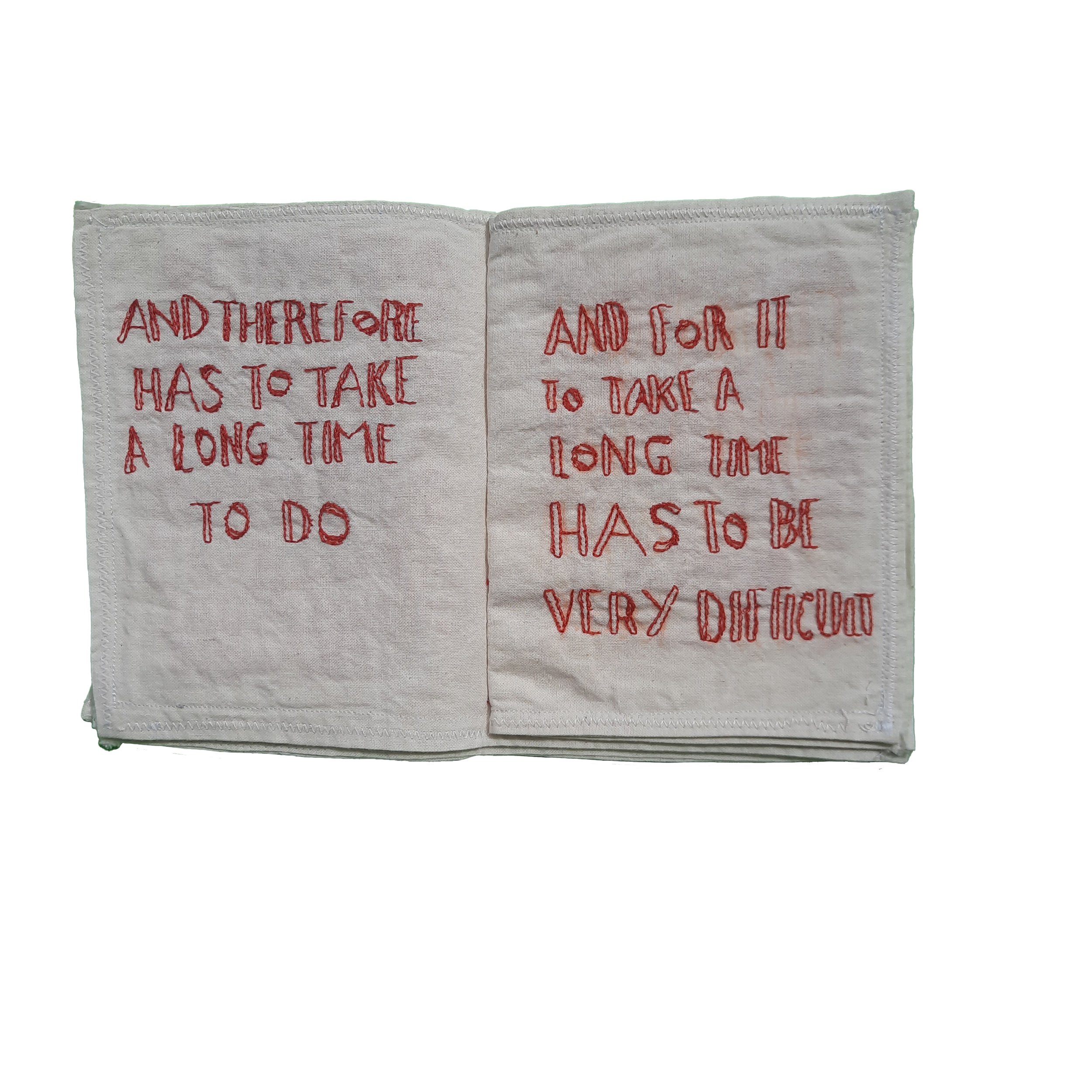 A piece of fabric with embroidered red text, with a stitched border along the edges.